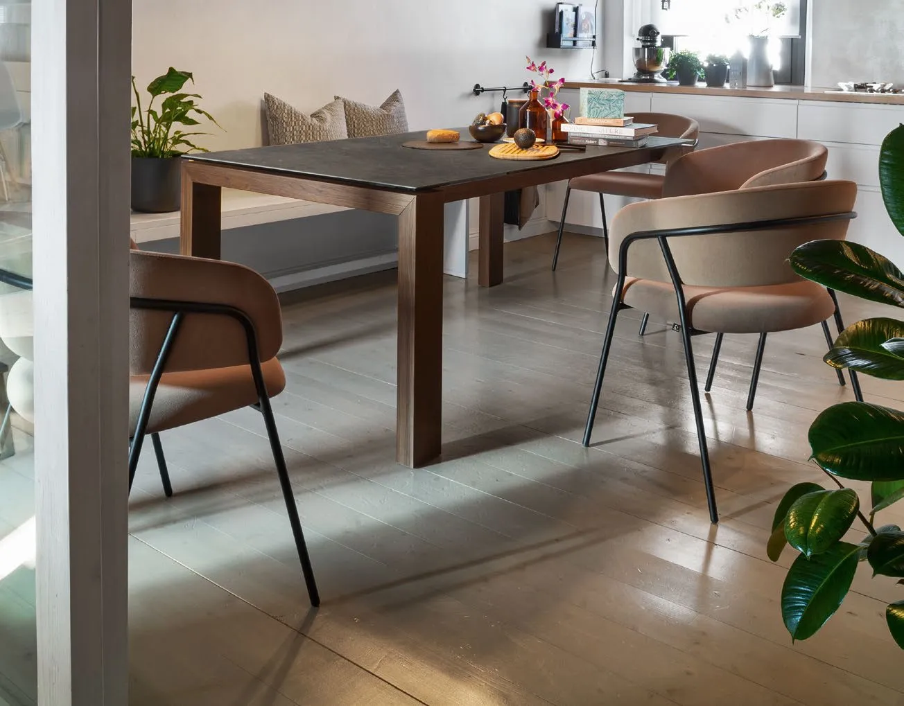 Tavolo Sigma Connubia in legno smoke con piano in ceramica scura e sedie imbottite su parquet chiaro
