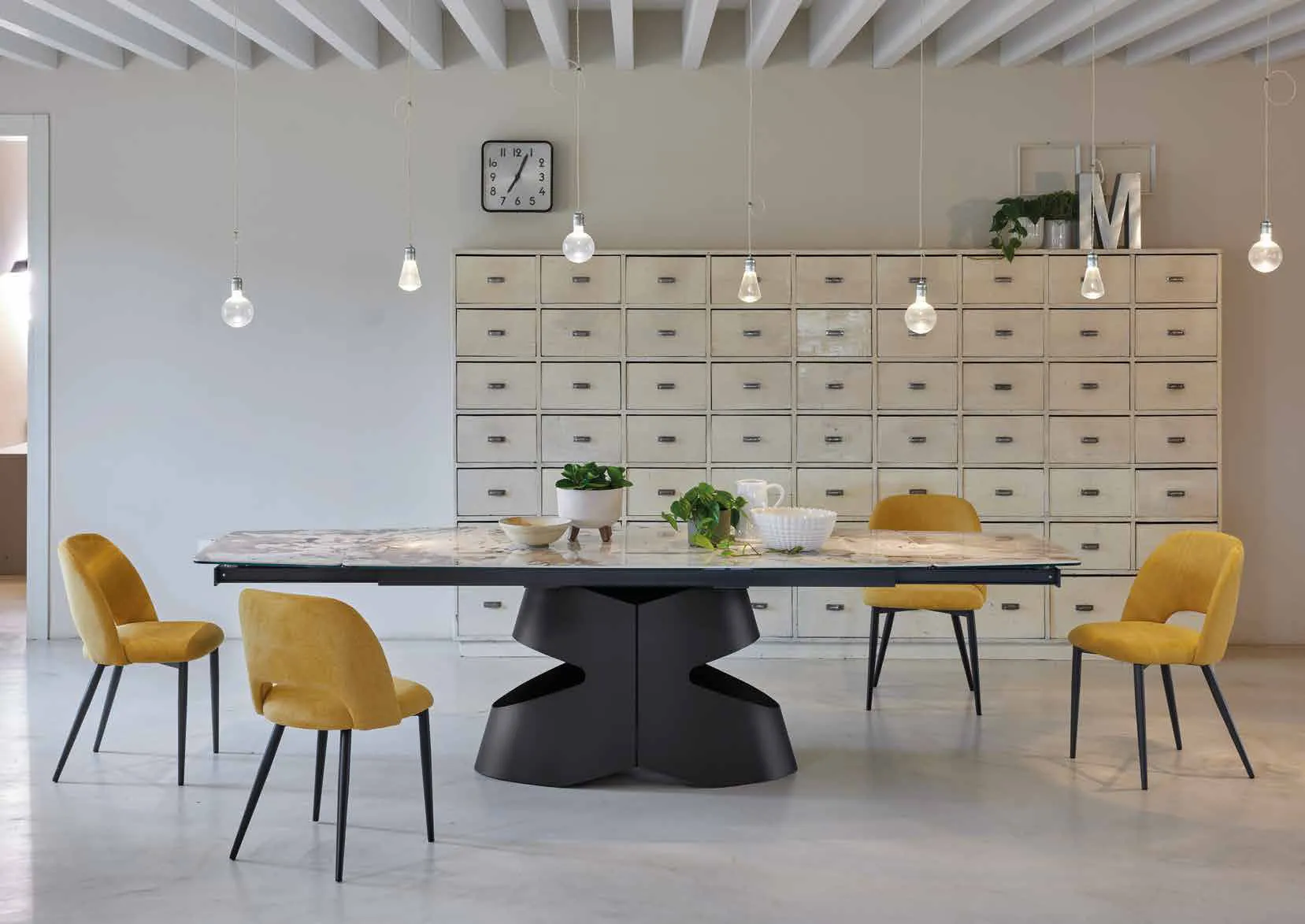 Tavolo Mirò Friulsedie con base antracite e piano Keramic chiaro, con sedie gialle in un open space