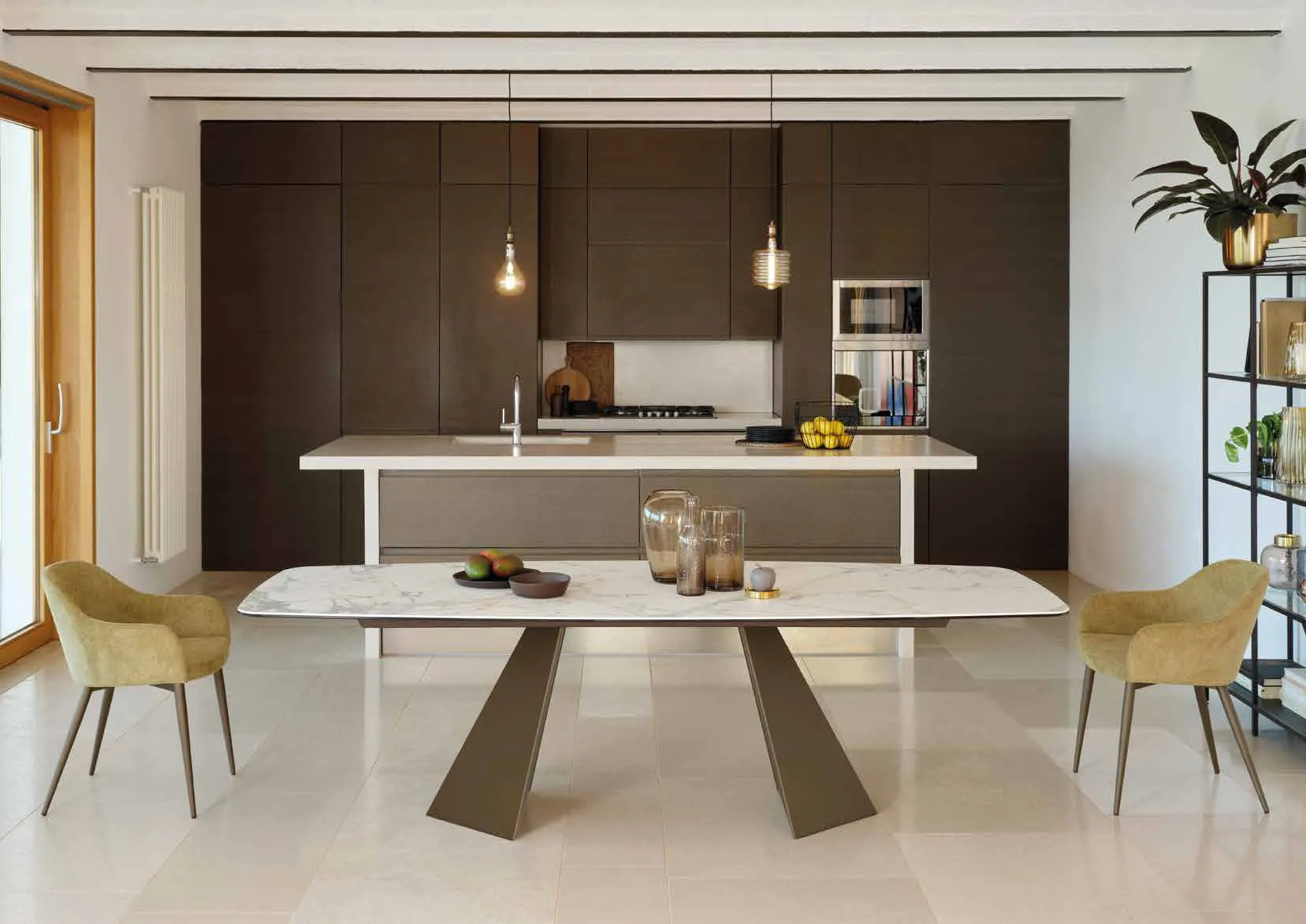 Tavolo Portland Friulsedie in ottone con piano Keramic Invisible White davanti a una cucina scura