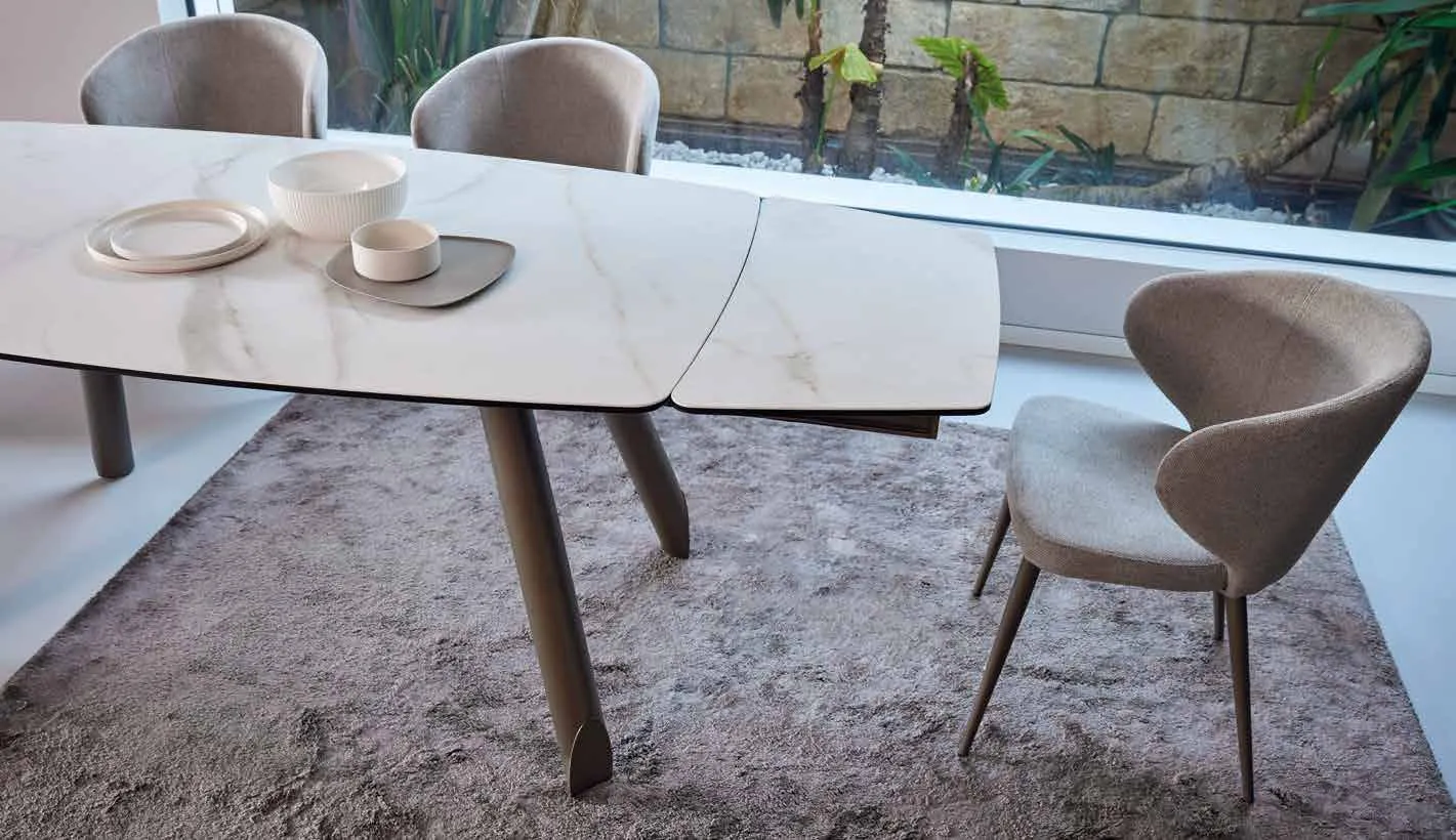 Tavolo Teseo Friulsedie in ottone con piano sagomato Keramic Calacatta e poltroncine Vivian