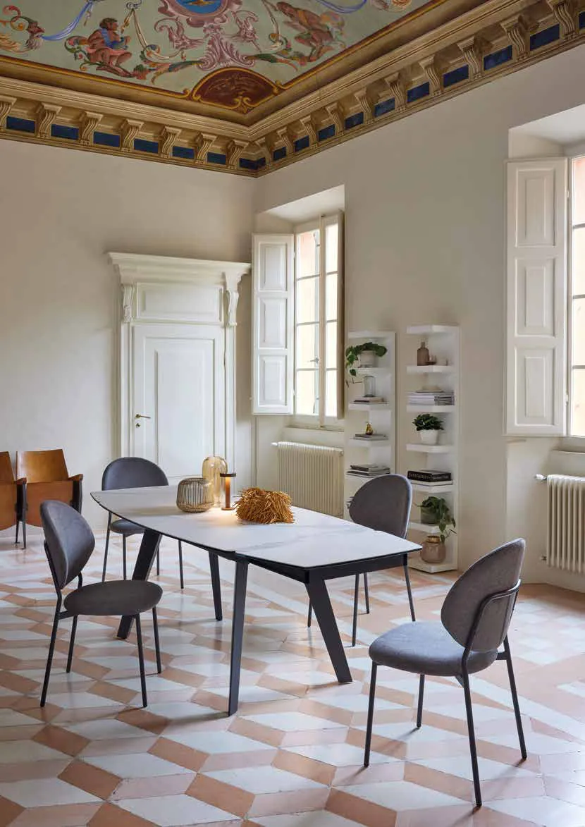 Tavolo Pegaso Friulsedie antracite con piano Keramic Statuario e sedie Vanilla in un salone affrescato