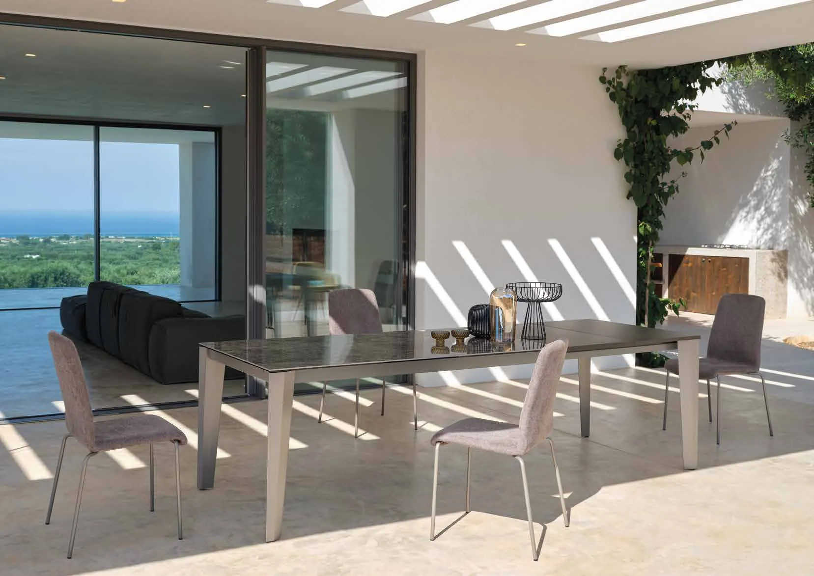 Tavolo Spencer Friulsedie in titanio con piano Keramic scuro sotto una pergola