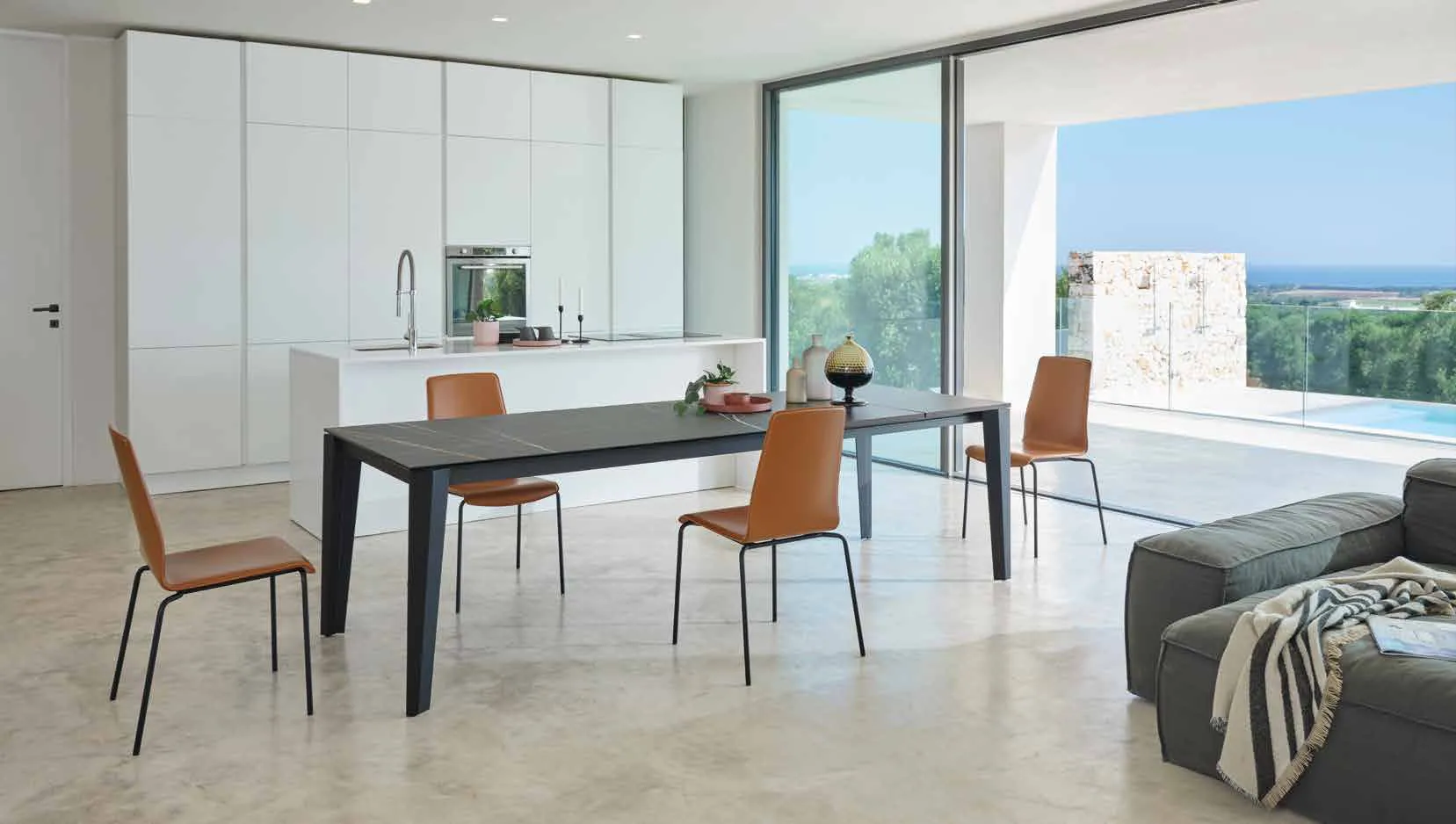 Tavolo Spencer Friulsedie nero con piano Keramic Sahara Noir e sedie cognac in un open space