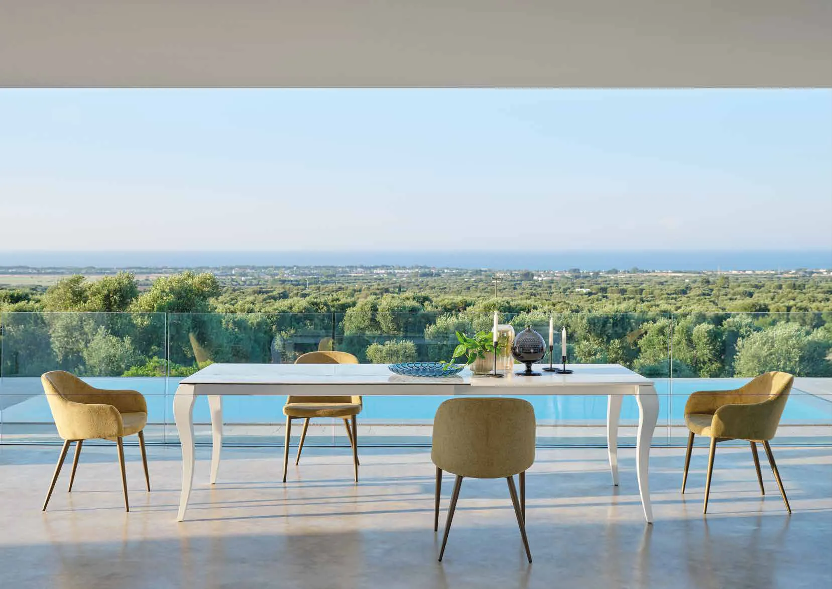 Tavolo allungabile Victor Friulsedie laccato bianco con sedie verdi su una terrazza vista mare