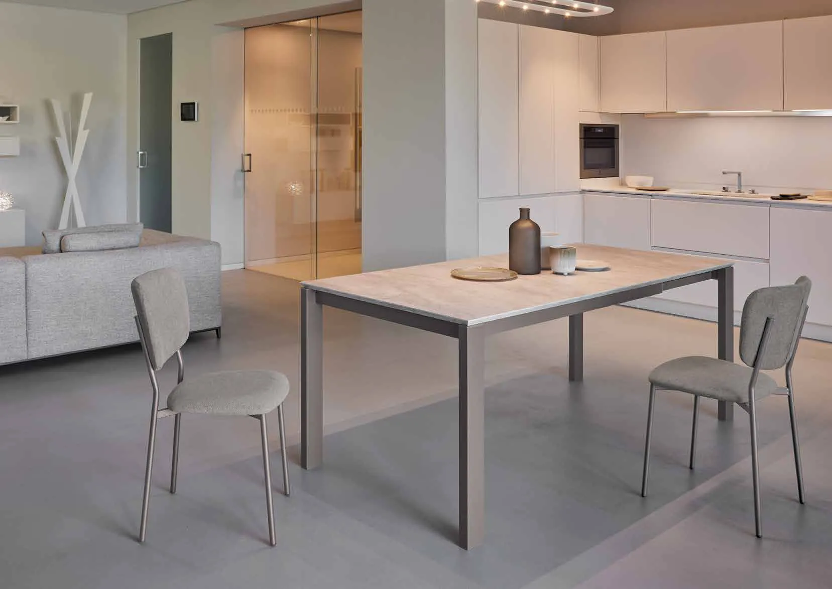 Tavolo allungabile Zenith Urban Friulsedie in titanio con piano effetto travertino in una cucina aperta