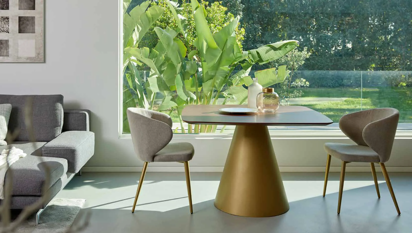 Tavolo Globe Friulsedie con base oro antico e piano sagomato in noce canaletto e poltroncine Vivian