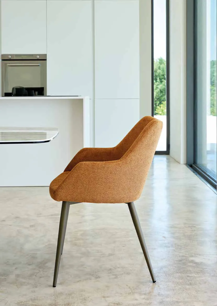 Poltroncina Janis Friulsedie in tessuto caramello con gambe in ottone in una cucina bianca