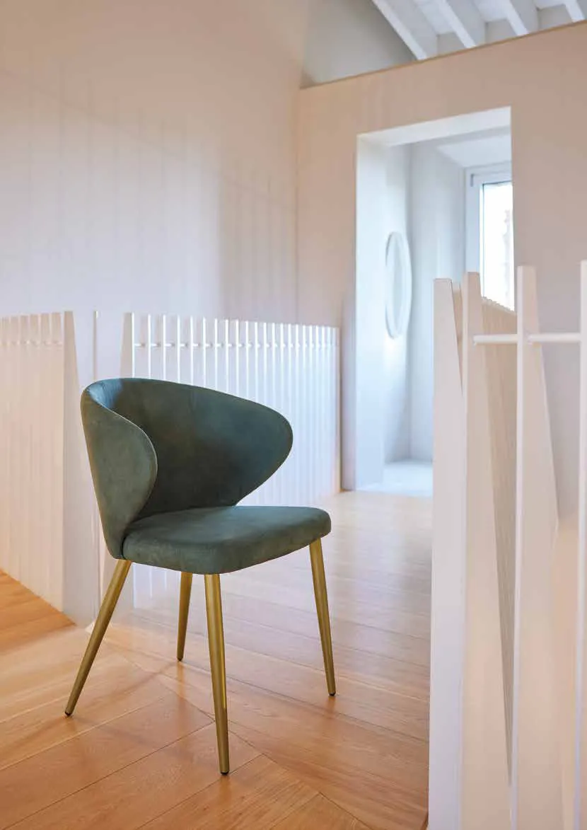 Poltroncina Vivian Friulsedie in tessuto verde bosco con gambe oro antico su un parquet