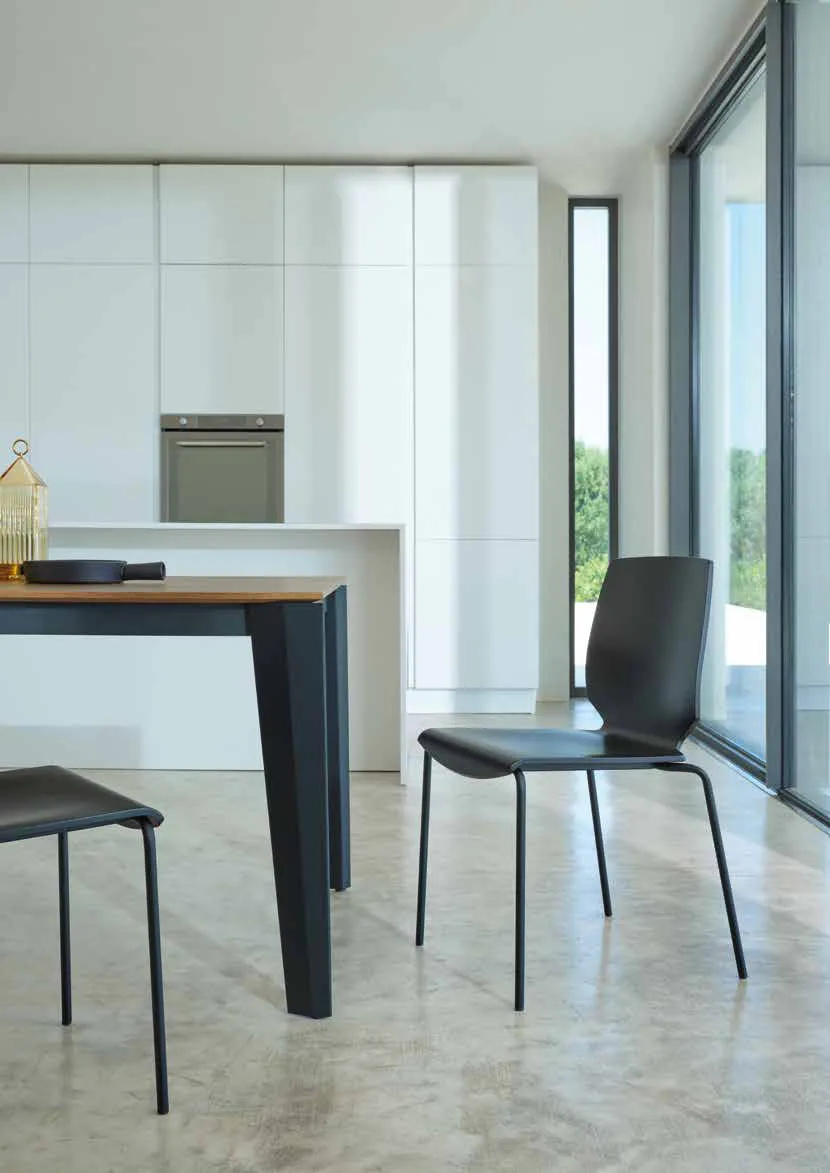 Sedie Shell Friulsedie con gambe nere e scocca in legno accanto al tavolo Spencer