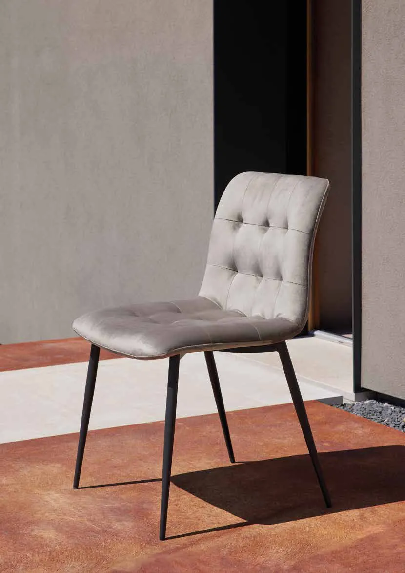 Sedia Kylian Friulsedie in velluto grigio con gambe antracite su un pavimento in cotto