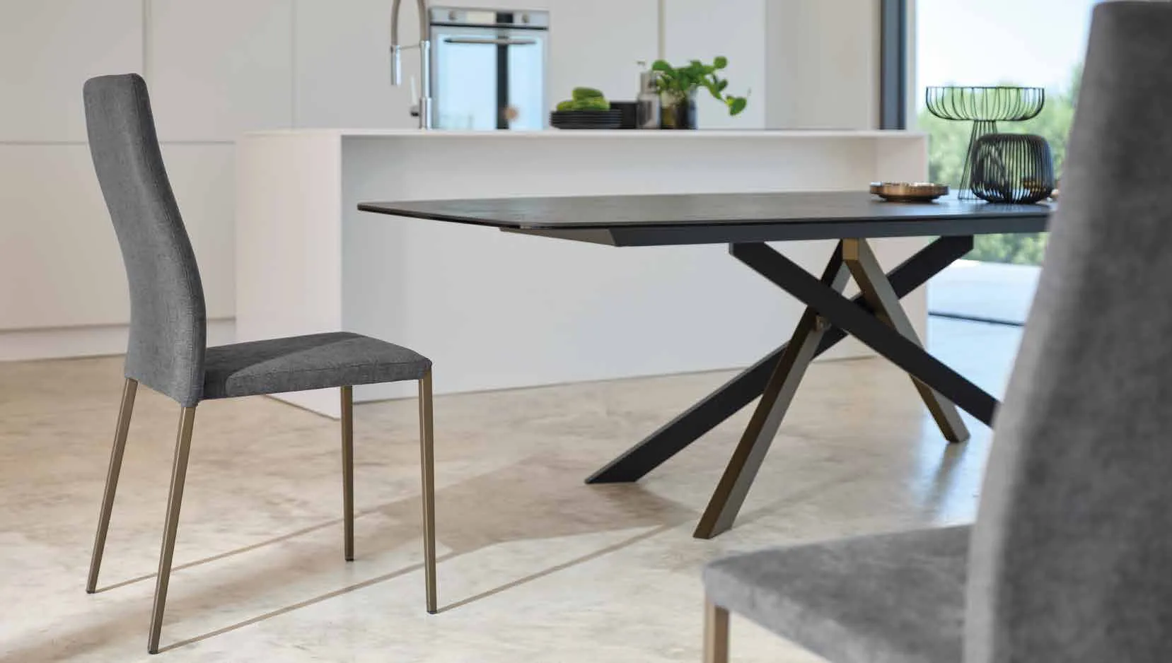 Sedia Tracy Friulsedie in tessuto grigio con gambe ottone accanto al tavolo Boston
