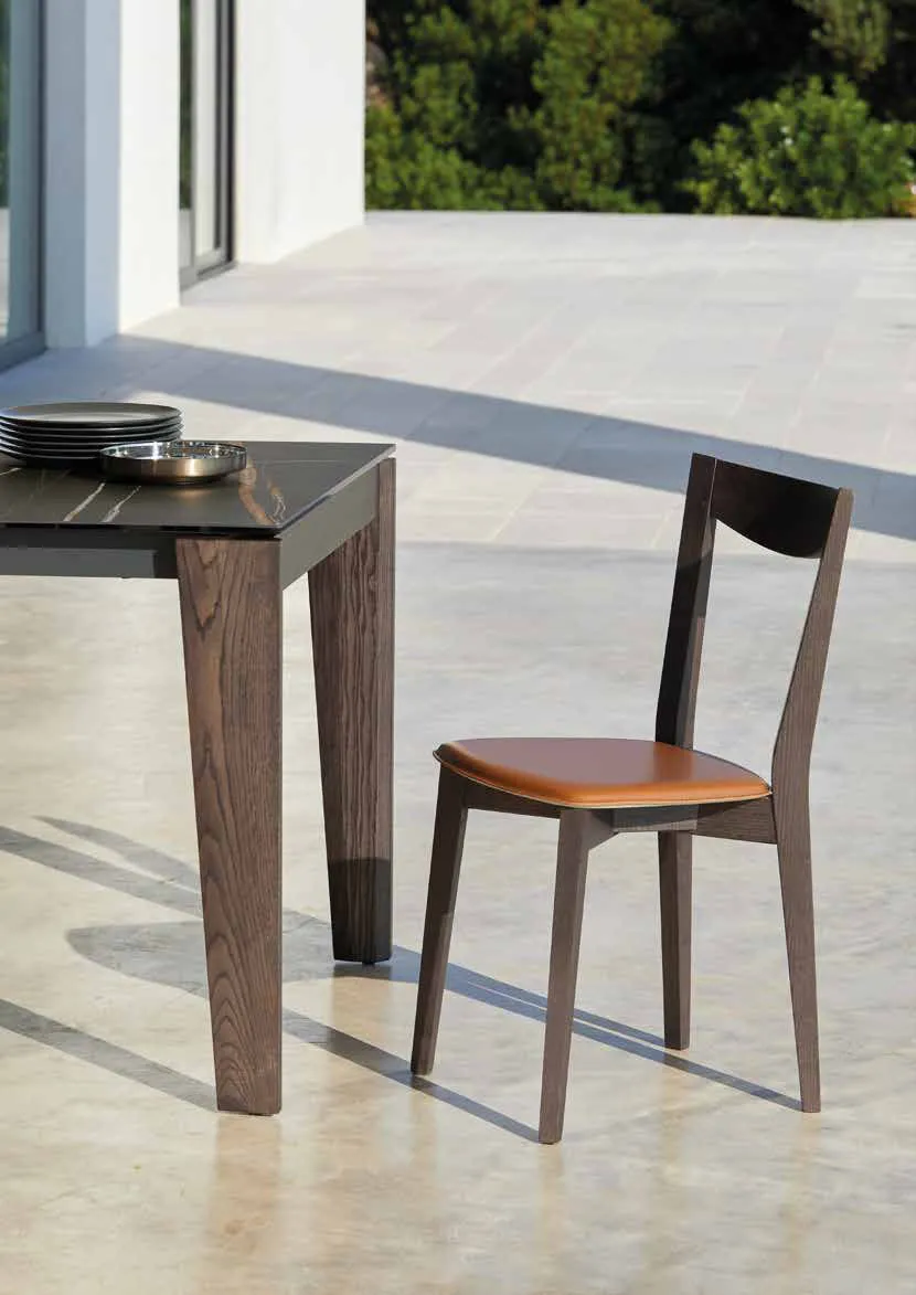 Sedie Smart Friulsedie in frassino bruciato e cuoio cognac accanto al tavolo Cartesio