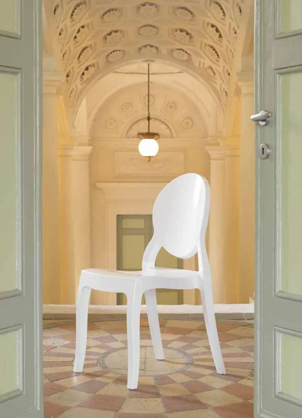 Sedia Musa Friulsedie in policarbonato bianco sotto un portico ad archi