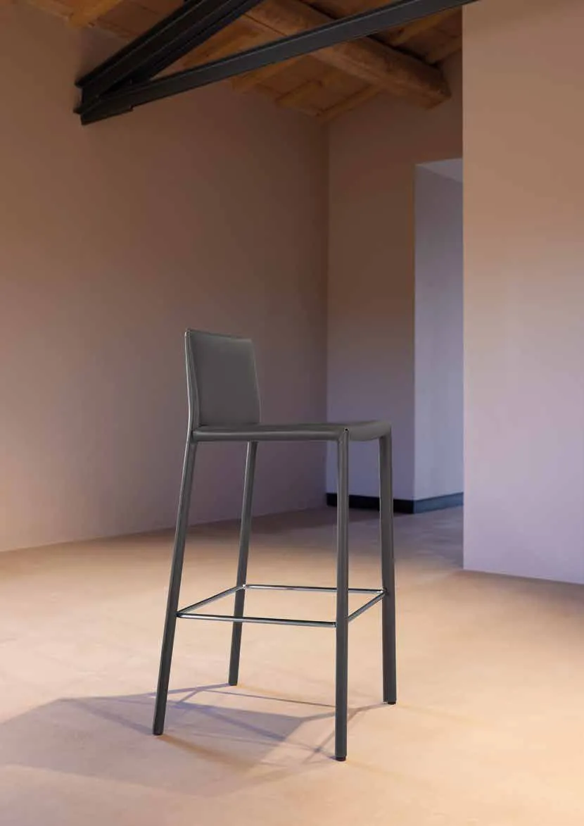 Sgabello Energy Friulsedie in cuoio rigenerato antracite sotto un soffitto a travi