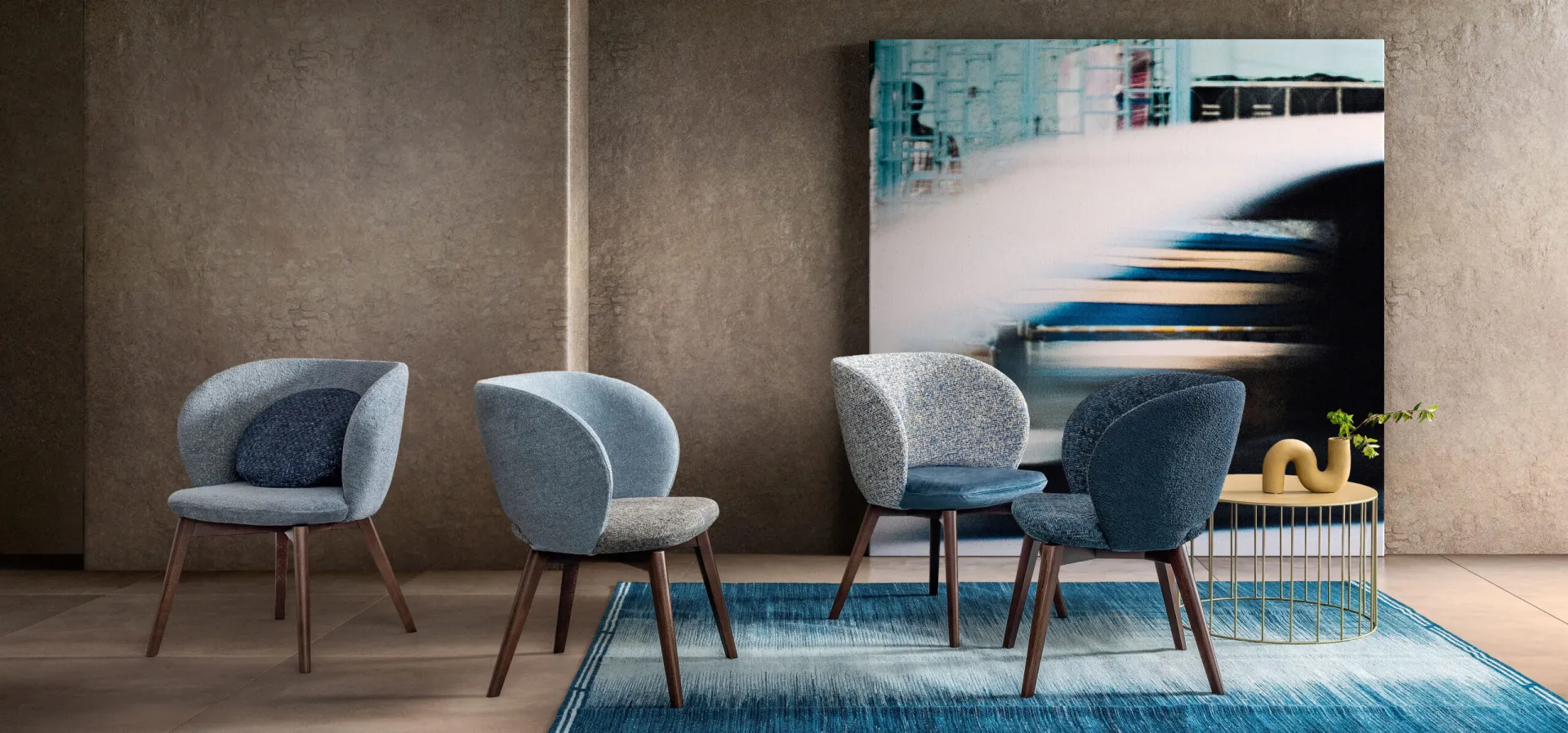 Quattro poltroncine Agave Samoa nei toni del blu e del grigio su gambe in legno, attorno a un tavolino
