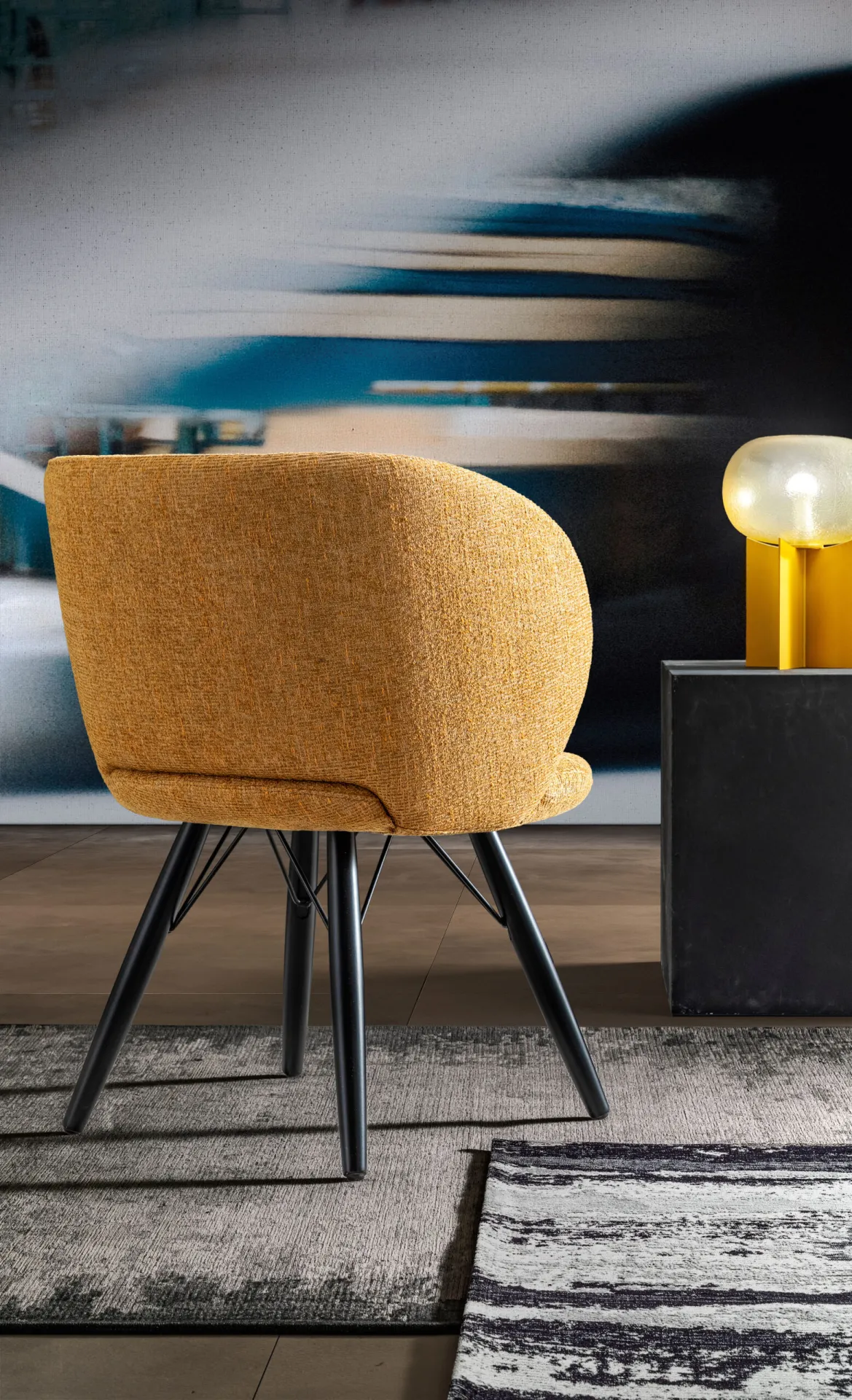 Poltroncina Agave Samoa gialla vista di tre quarti da dietro, con lo schienale curvo