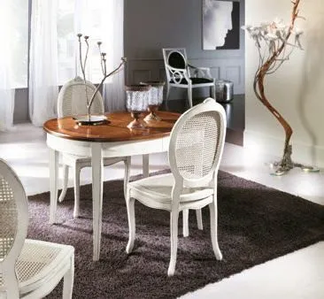 Sedie ovaline Trend Style Imba laccate attorno a un tavolo rotondo su tappeto scuro