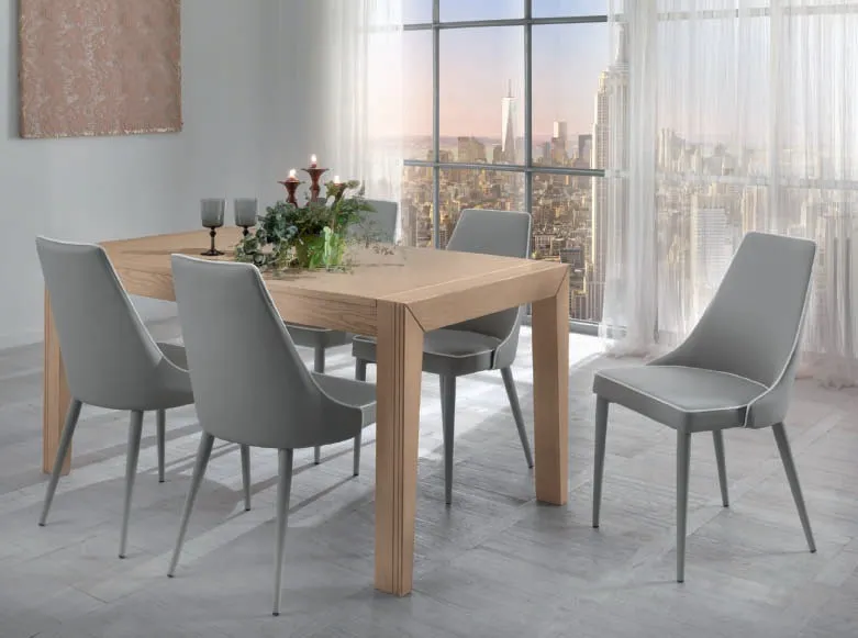 Sedie imbottite grigie House Project Imba attorno a un tavolo in rovere davanti a una vetrata