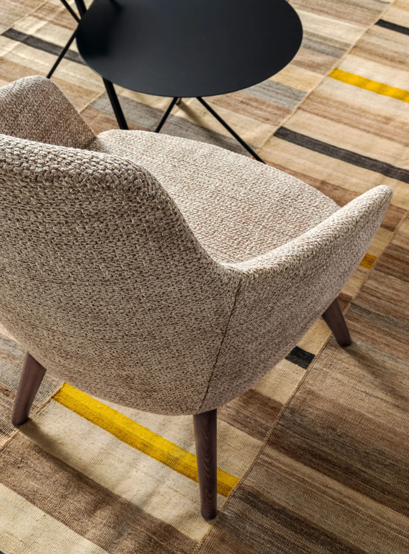 Poltrona Kora Samoa beige vista dall'alto su un tappeto a righe