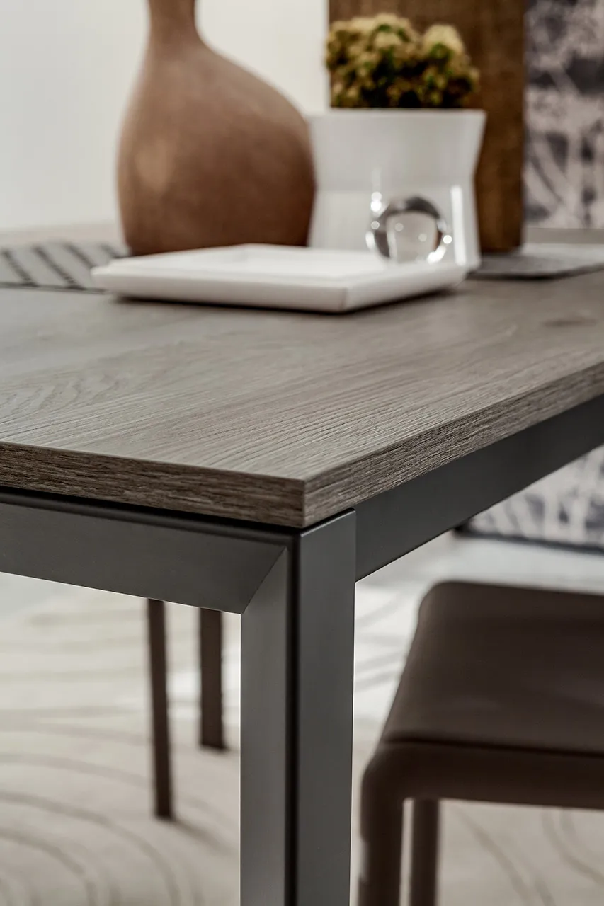 Angolo del piano effetto rovere e gamba grigia del tavolo Mauro La Primavera