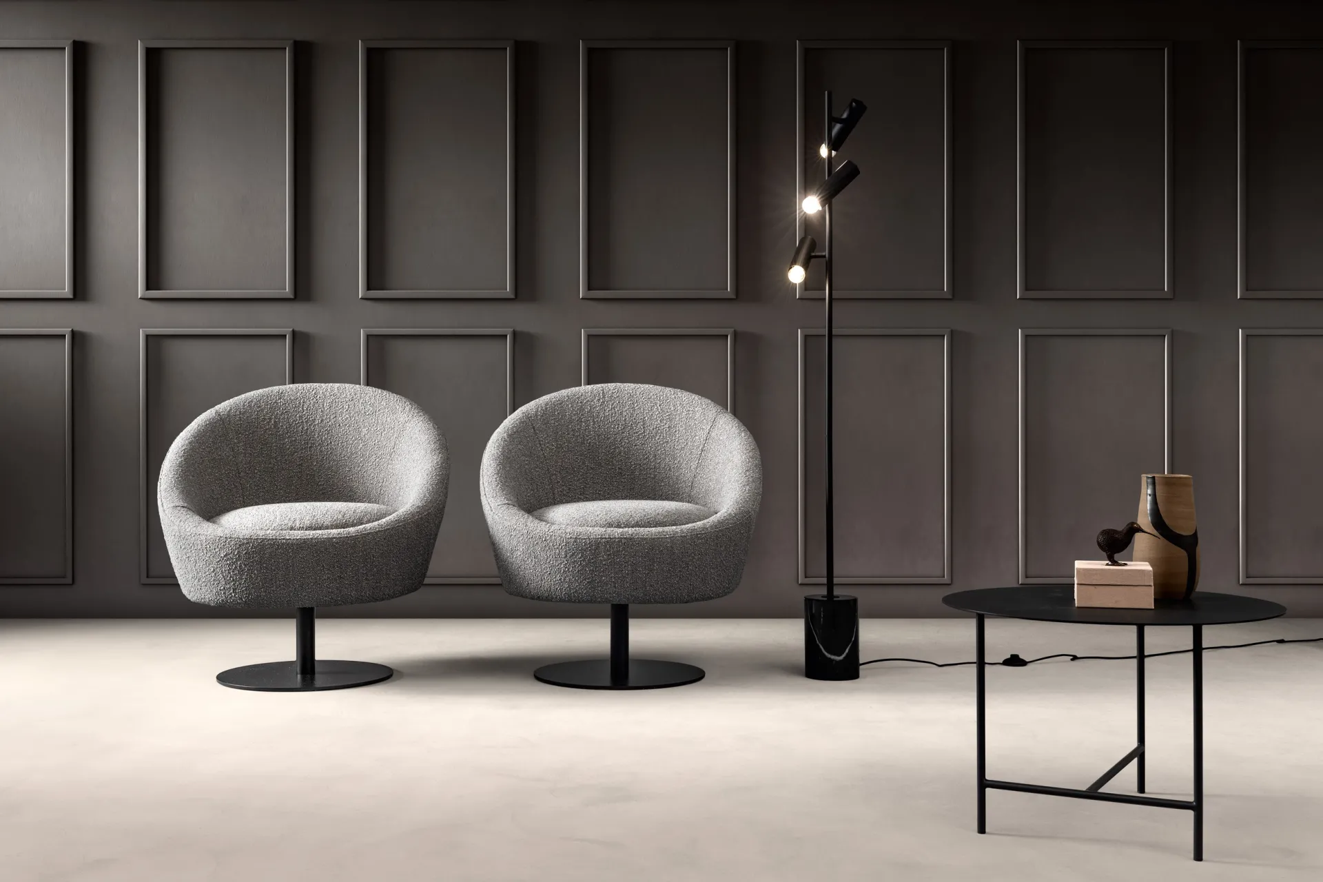 Due poltroncine Bubble Samoa in bouclé grigio su base a disco, davanti a una parete a riquadri