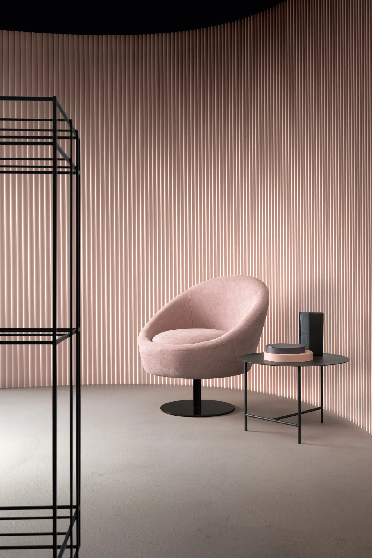 Poltroncina Bubble Samoa rosa cipria su base a disco, accanto a un tavolino in metallo