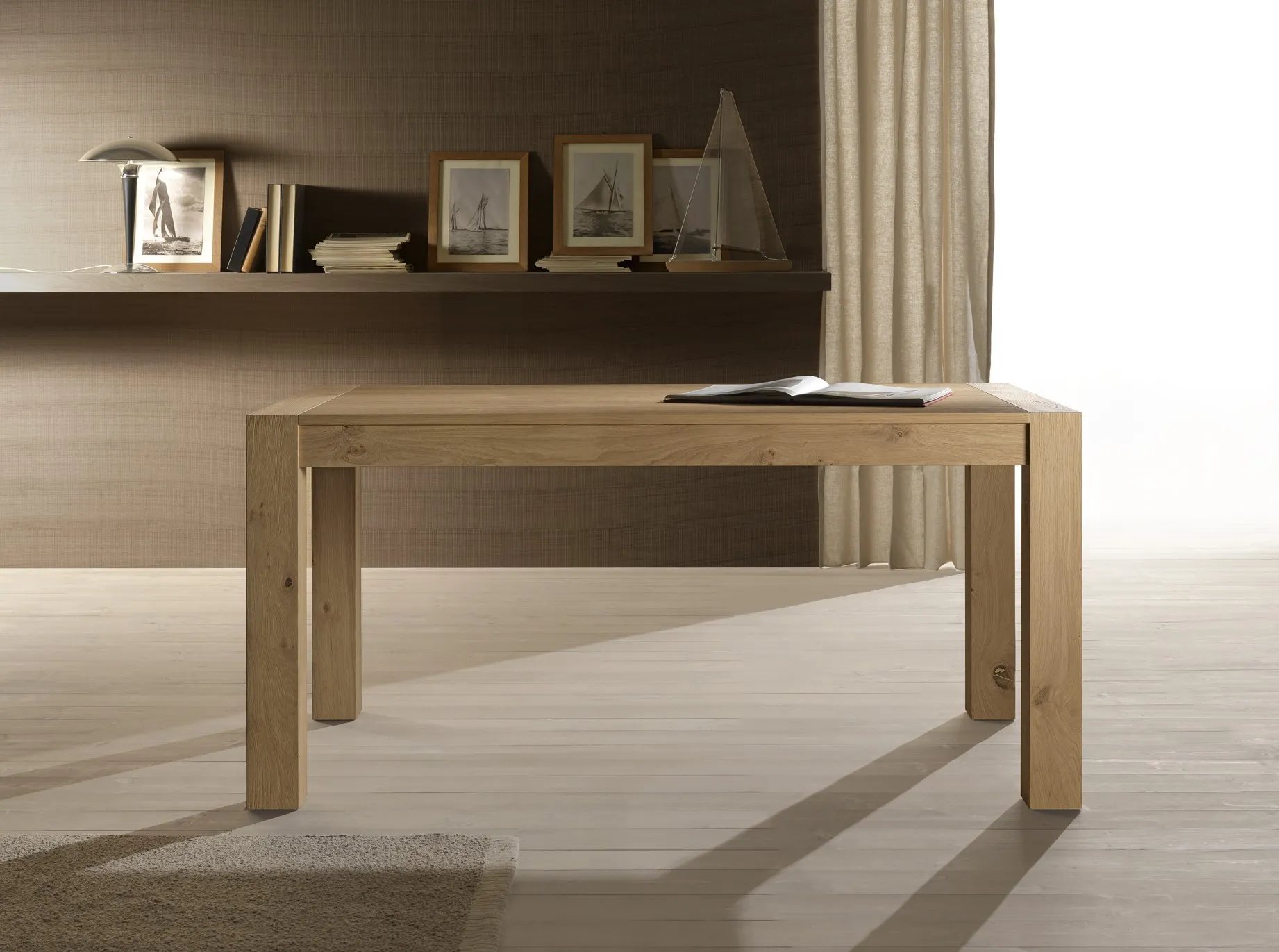 Tavolo Melbourne Pizzolato in legno naturale davanti a una mensola con cornici