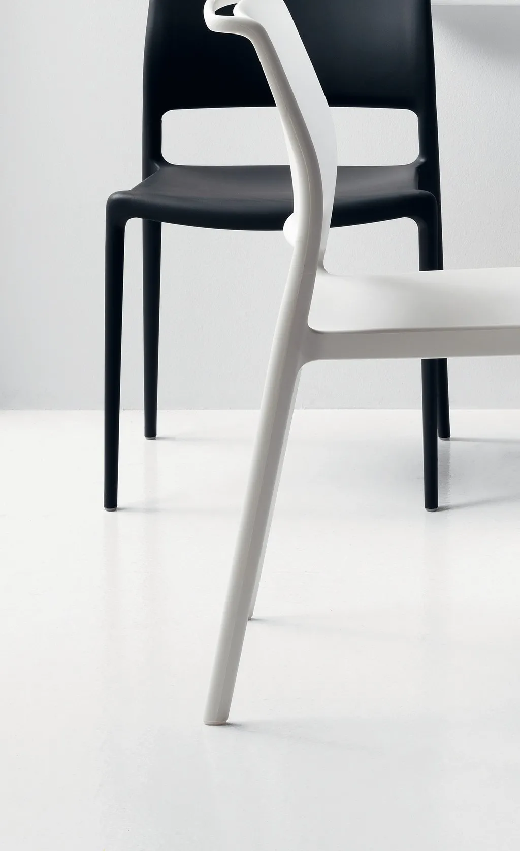 Sedie Ara 310 Scavolini nere e bianche in un ambiente chiaro, con lo schienale aperto in vista