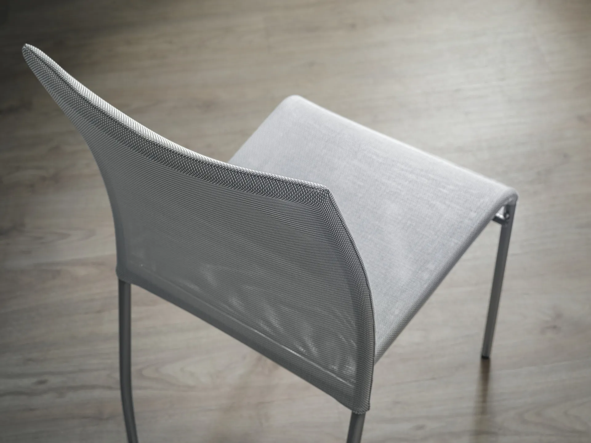 Dettaglio dall'alto della sedia Avenue Scavolini con schienale in tessuto grigio e bordo a contrasto