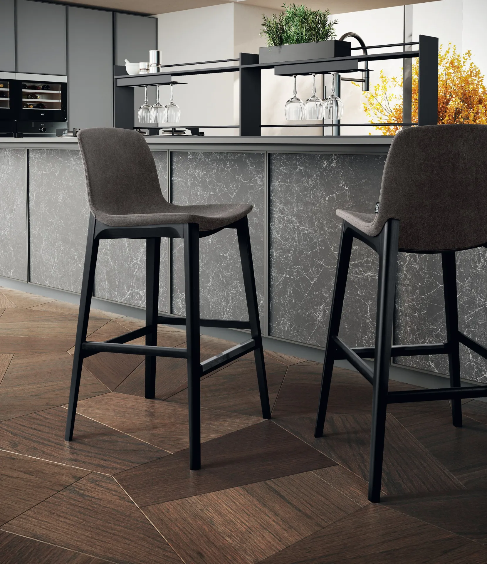 Sgabelli Boutique Scavolini grigi accanto a una penisola in pietra su parquet a spina di pesce