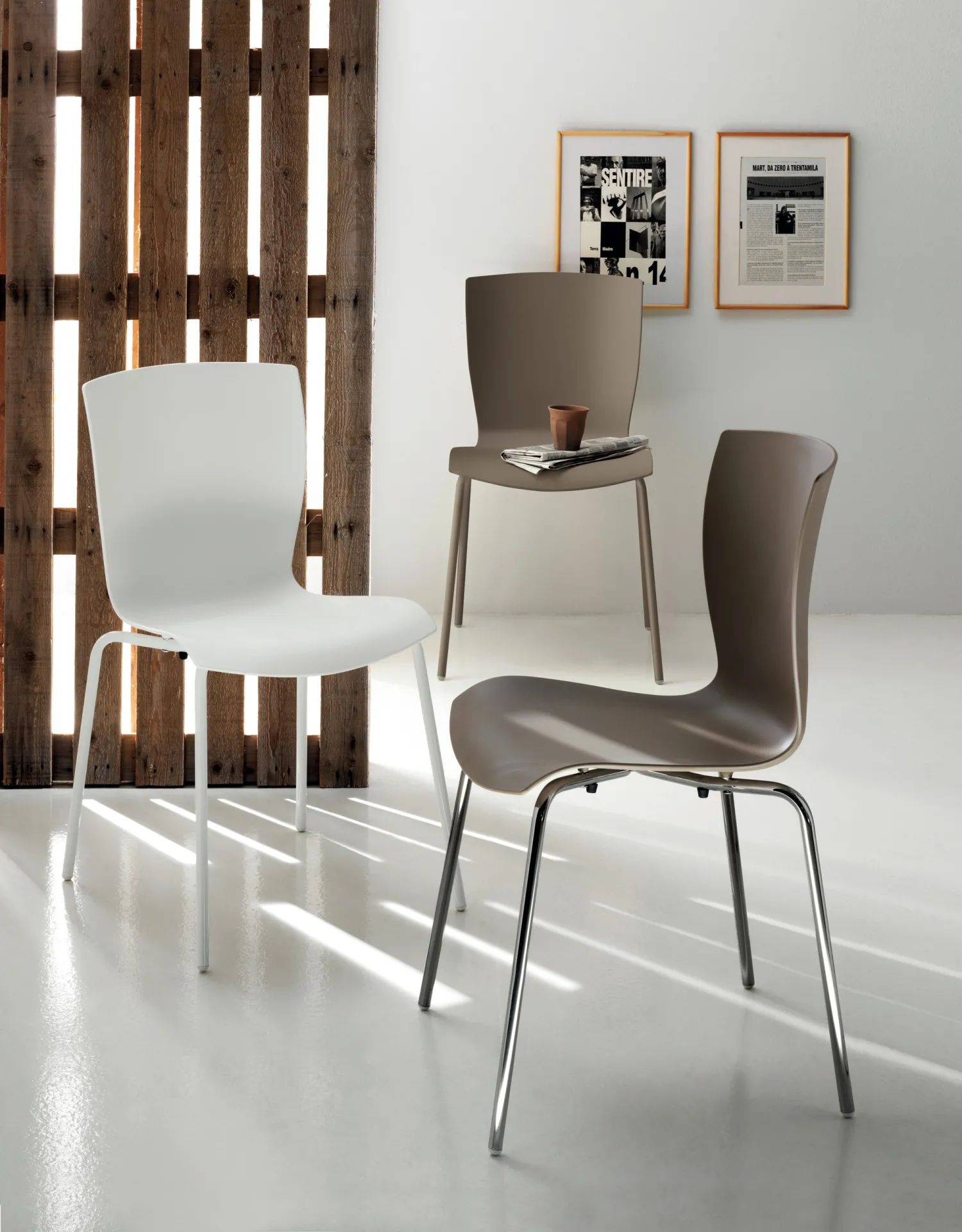 Sedie Chatty Scavolini bianca e tortora davanti a un paravento in legno