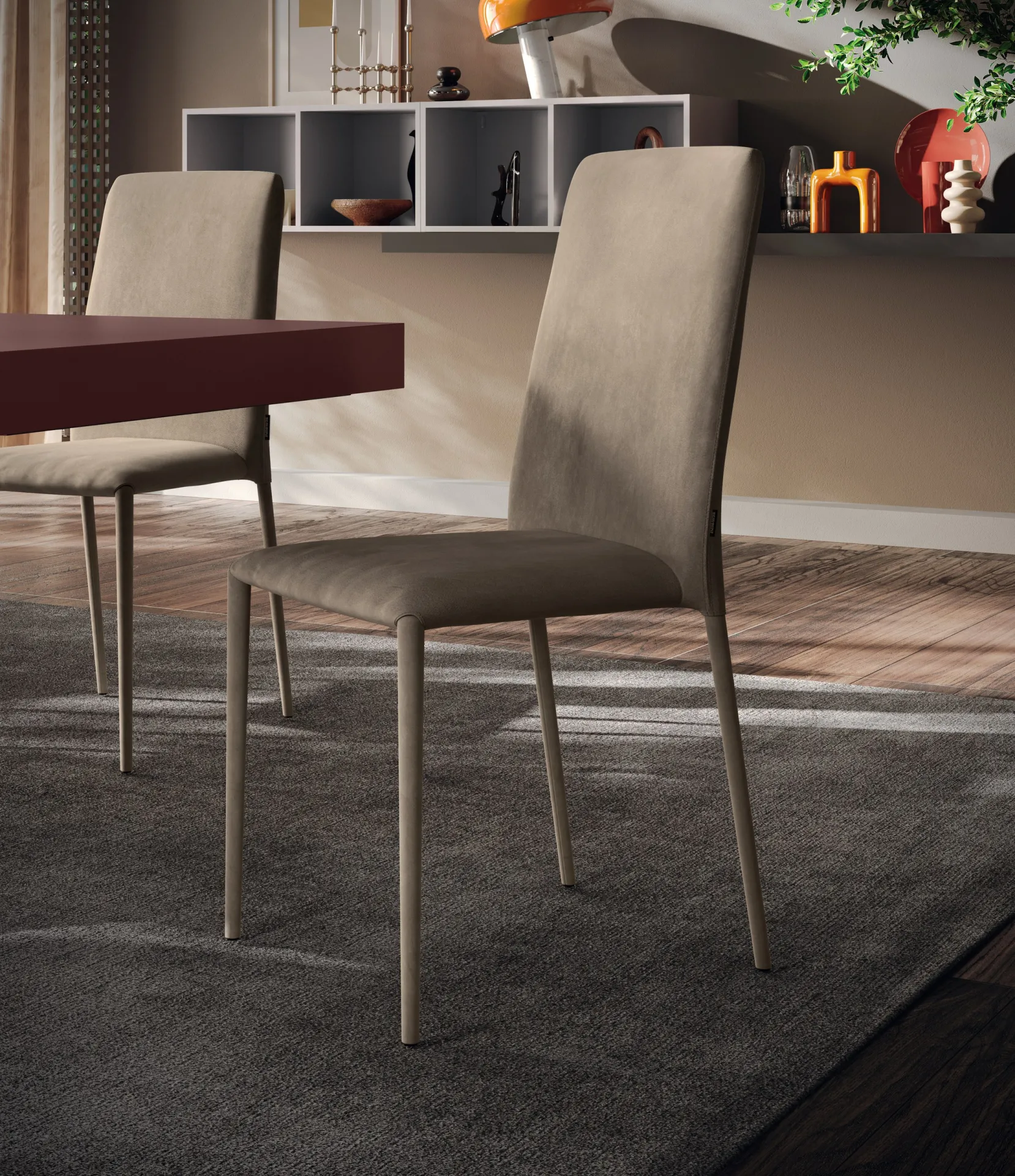 Sedie Cloe Scavolini color tortora con gambe rivestite attorno a un tavolo dal piano rosso scuro