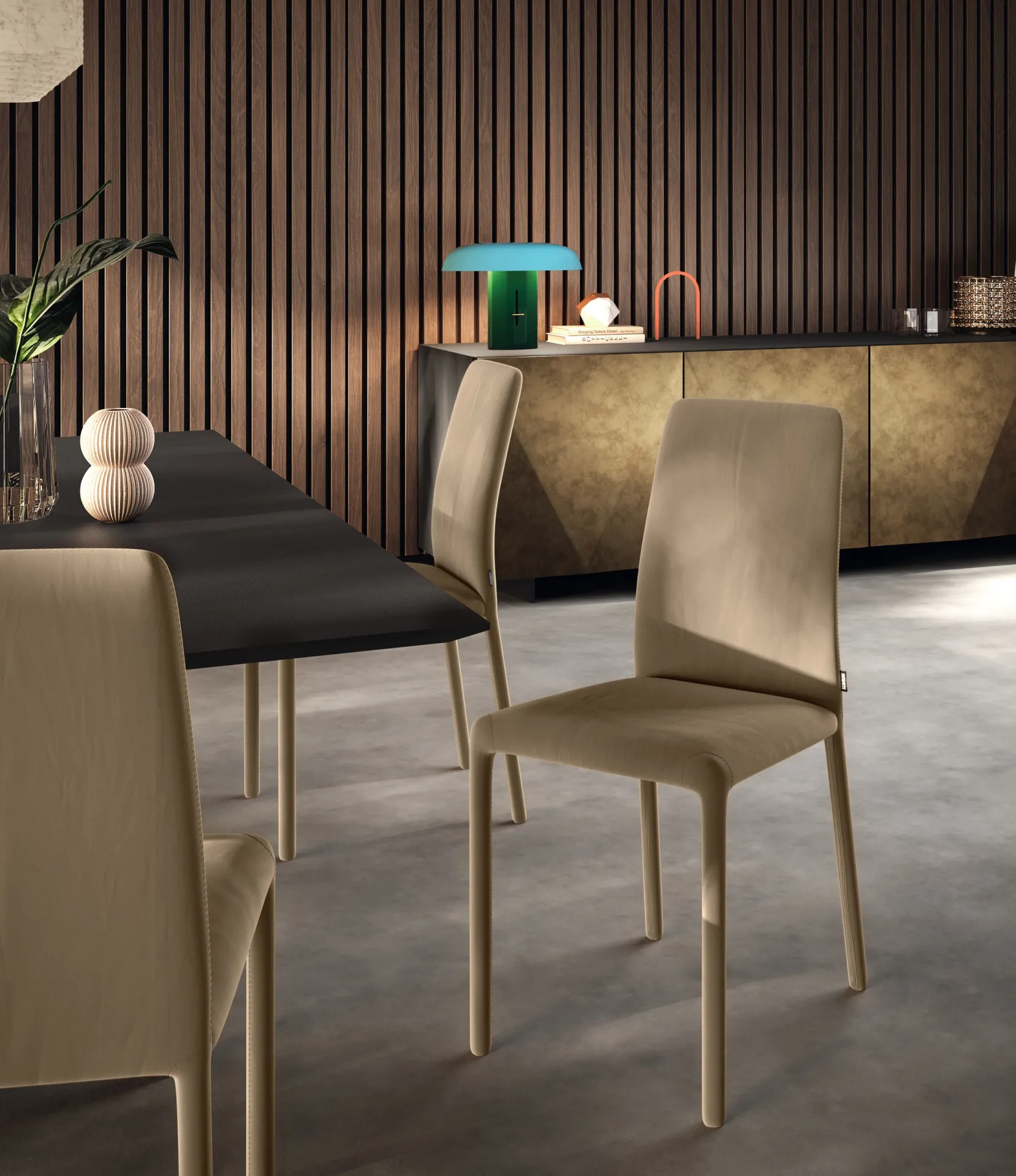 Sedie Coat Scavolini color oliva chiaro davanti a una parete a listelli e a una madia dorata