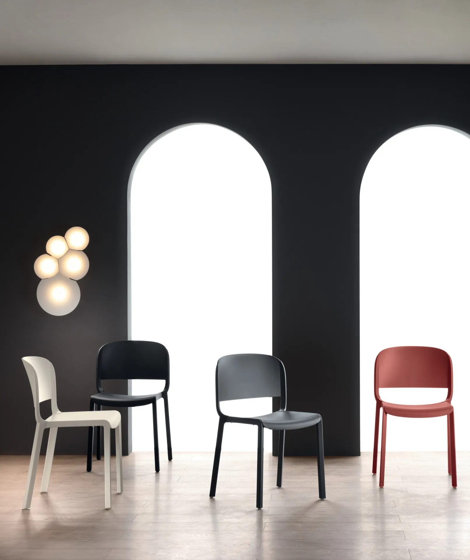 Sedie Dome 260 Scavolini bianca, nera, grigia e rossa in un ambiente con grandi arcate