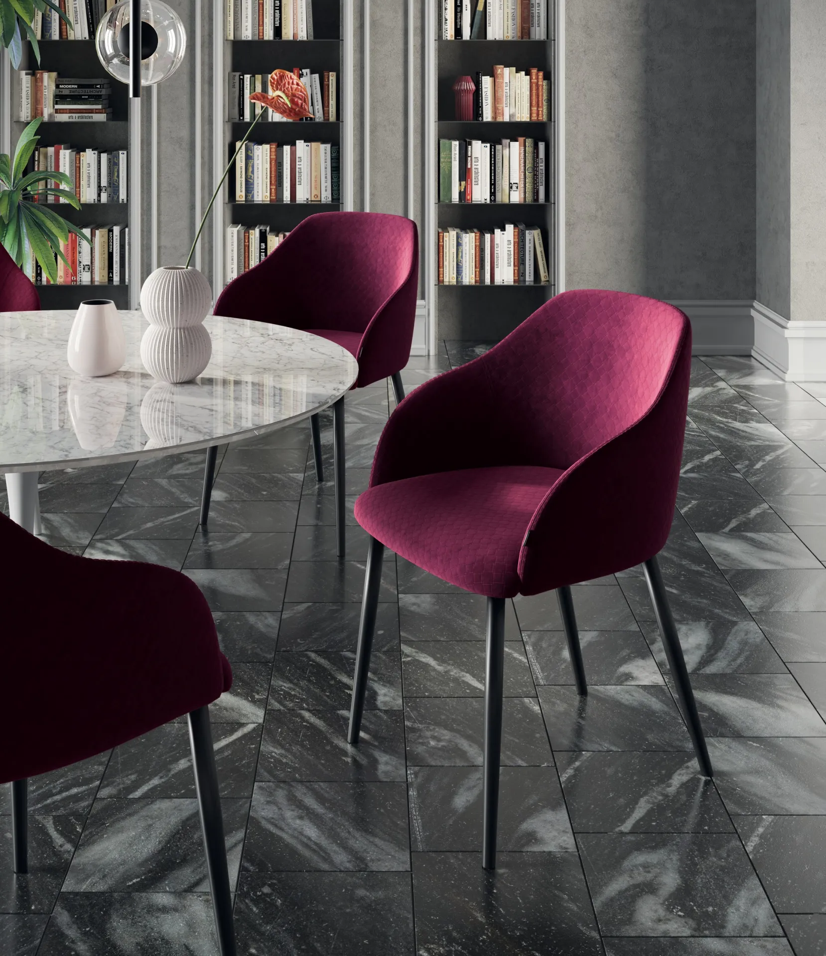 Sedie Era Scavolini color vinaccia attorno a un tavolo tondo in marmo in una sala con librerie