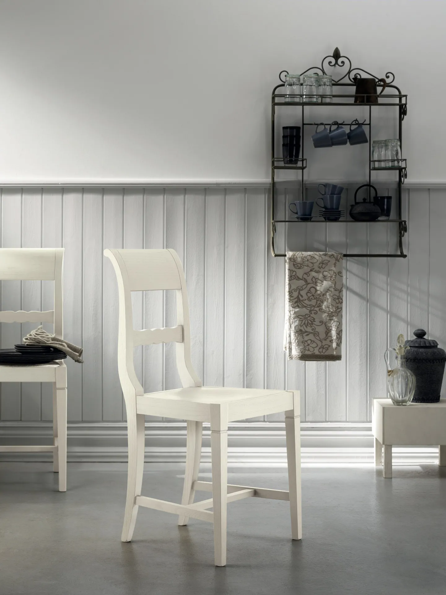 Sedia Grand Relais Scavolini laccata avorio con fondino in paglia in una stanza con boiserie grigia