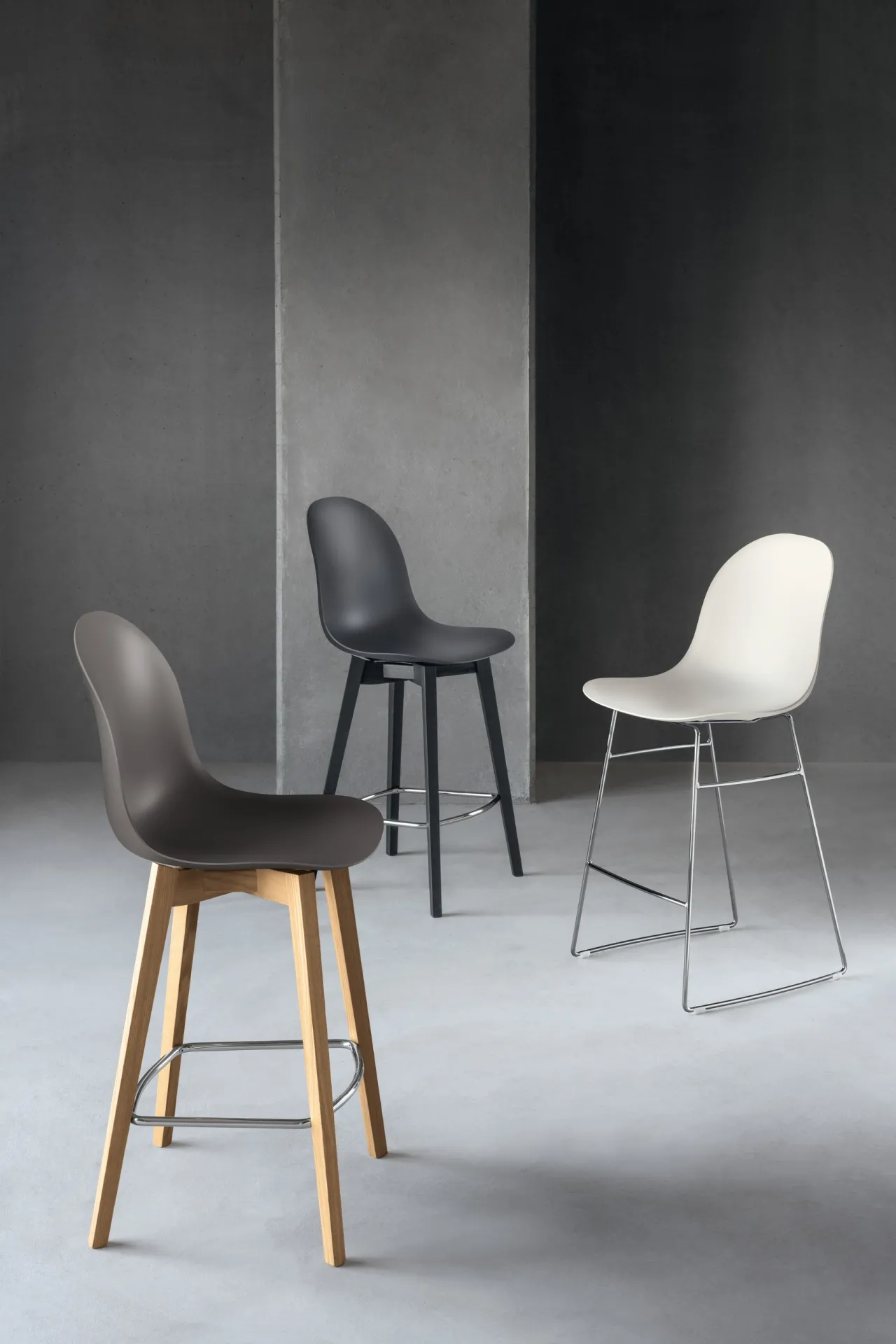 Sgabelli Hero Scavolini in un ambiente grigio, in primo piano quello con gambe in frassino