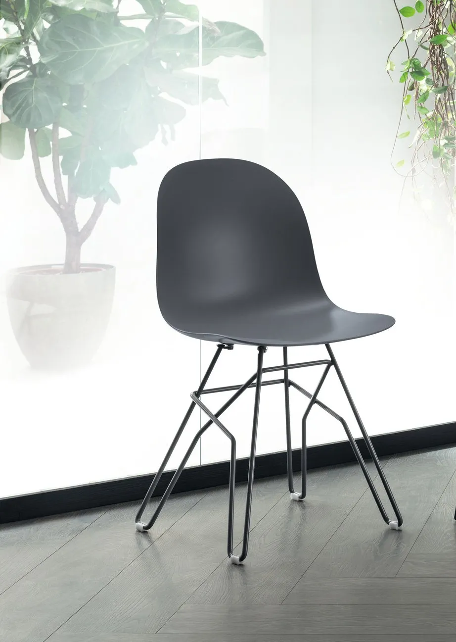 Sedia Hero Scavolini grigio antracite con base intrecciata davanti a una vetrata con piante