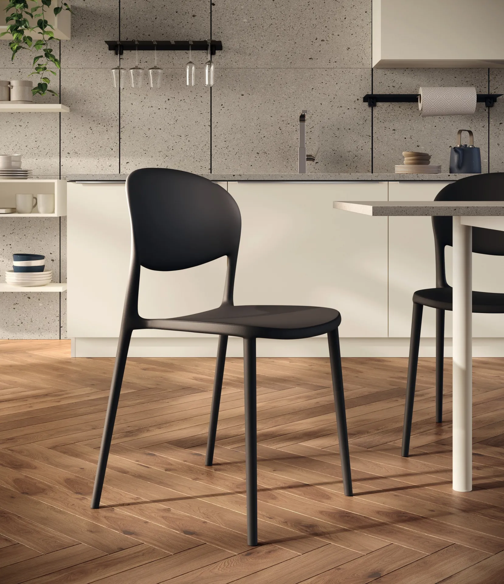 Sedia House Scavolini nera accanto a un tavolo bianco su parquet a spina di pesce