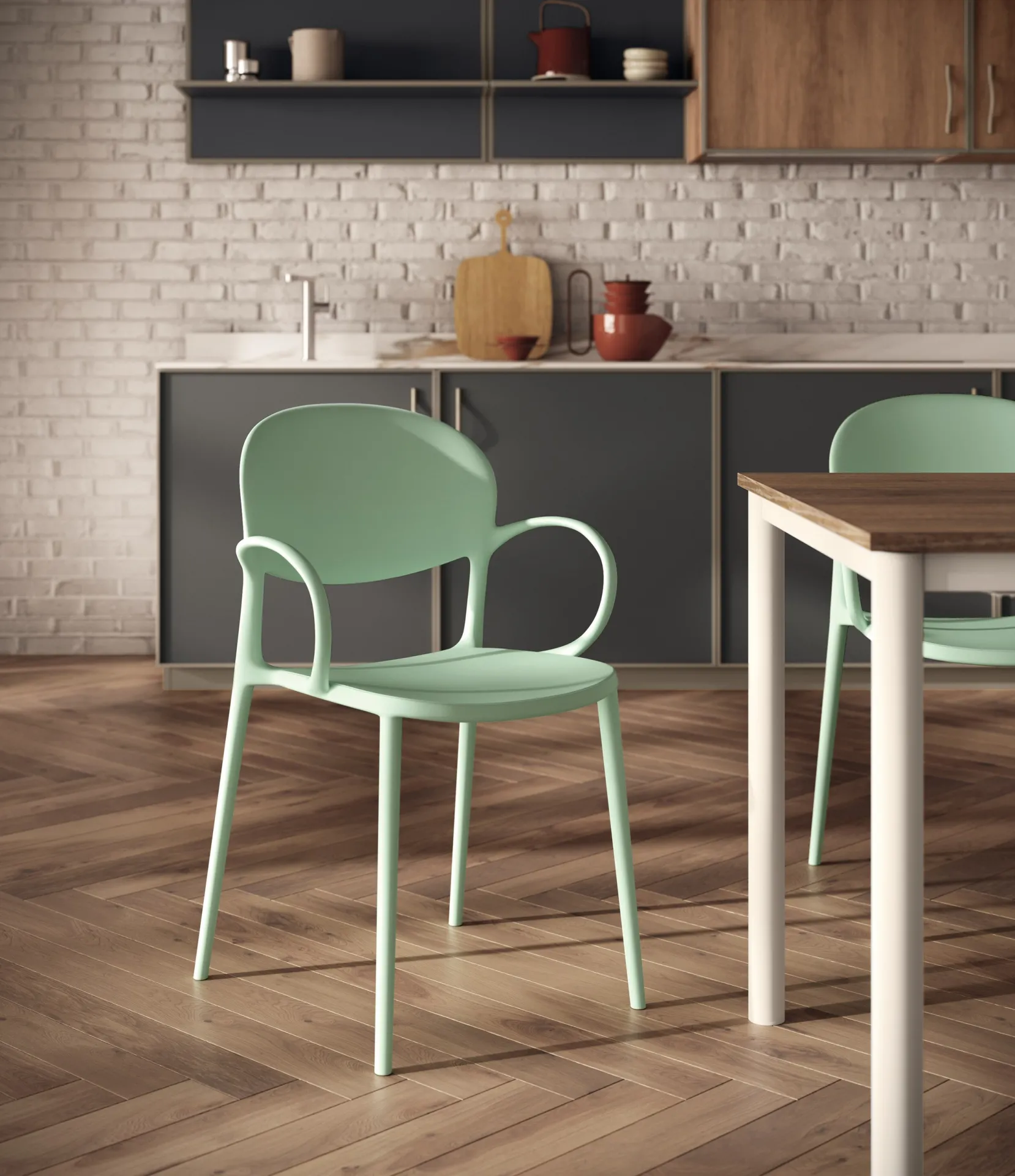 Sedia House con bracciolo Scavolini verde salvia vicino a un tavolo in legno e a una parete di mattoni