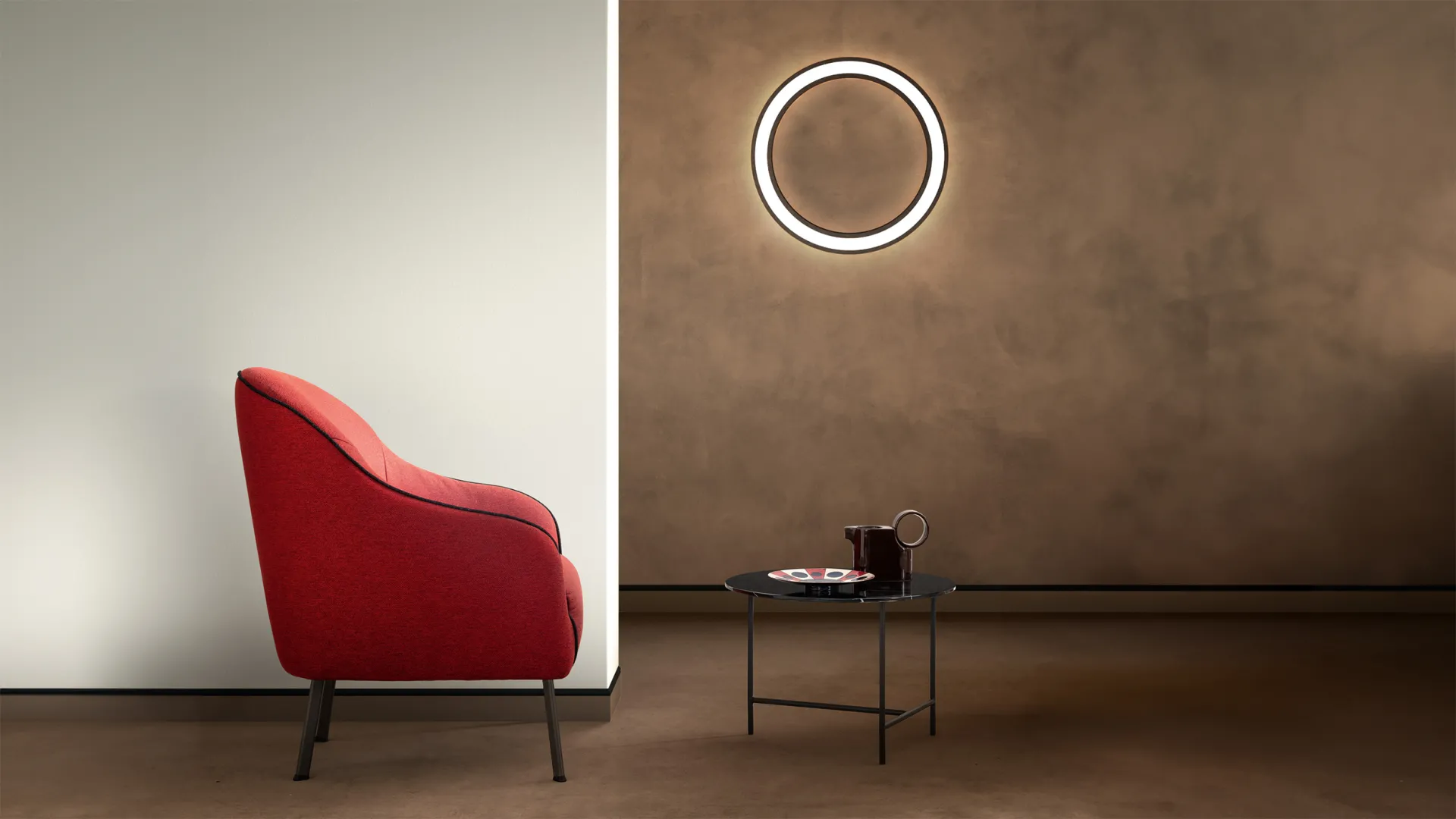 Poltroncina Sasha Samoa rossa con profilo scuro su gambe sottili, accanto a un tavolino