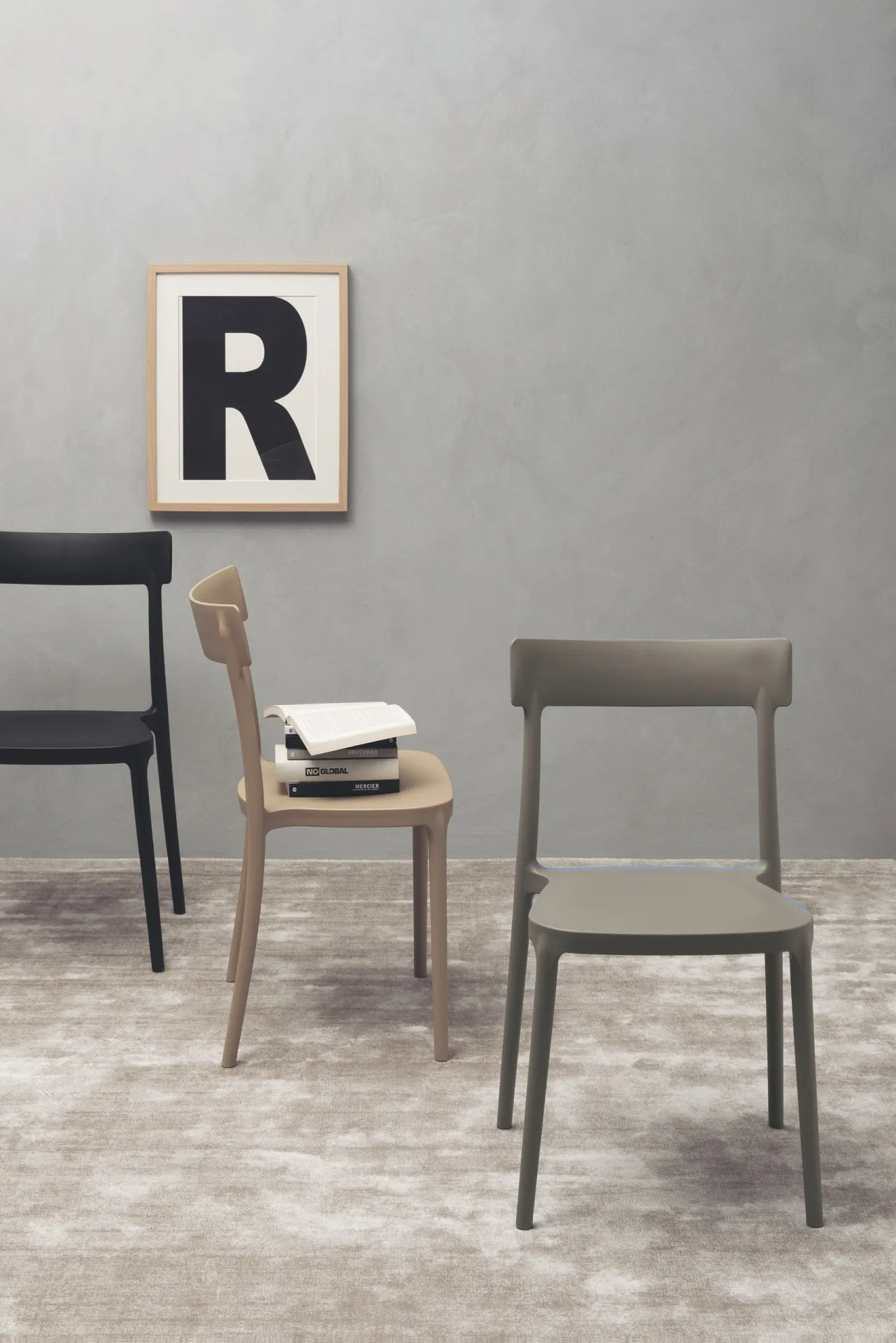 Sedia Lean Scavolini color tortora accanto a una sedia in legno e a un quadro con lettera R