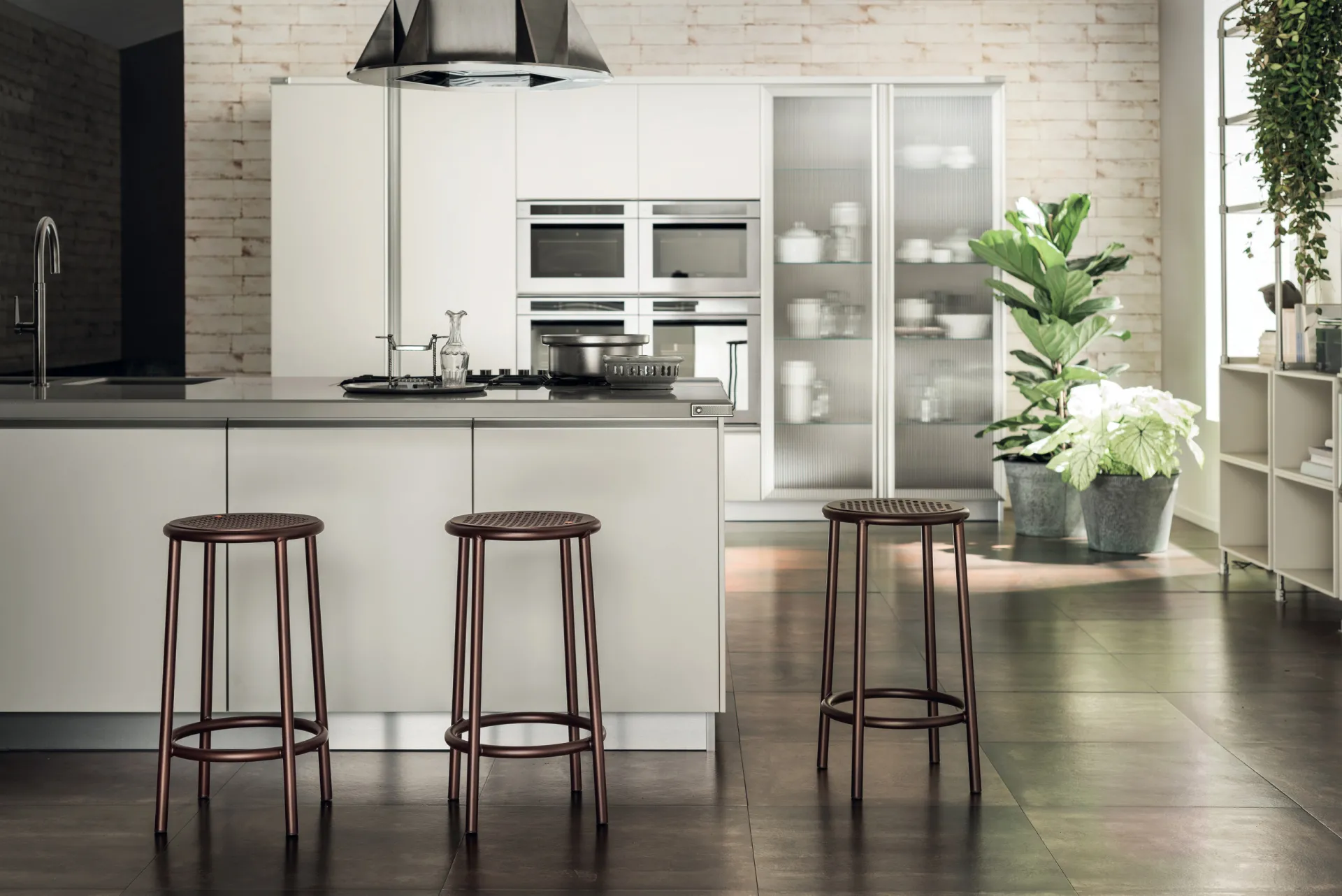 Sgabelli Nizza Scavolini davanti a un'isola bianca in una cucina con mattoni chiari