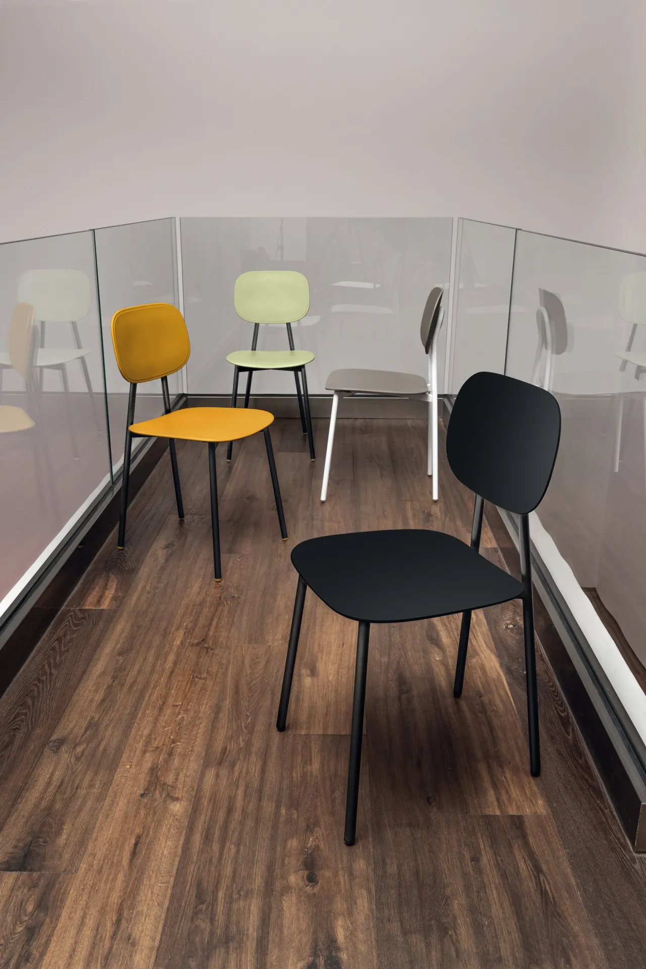 Sedie Painter Young Scavolini gialla, bianca, verde e nera su un ballatoio con parquet