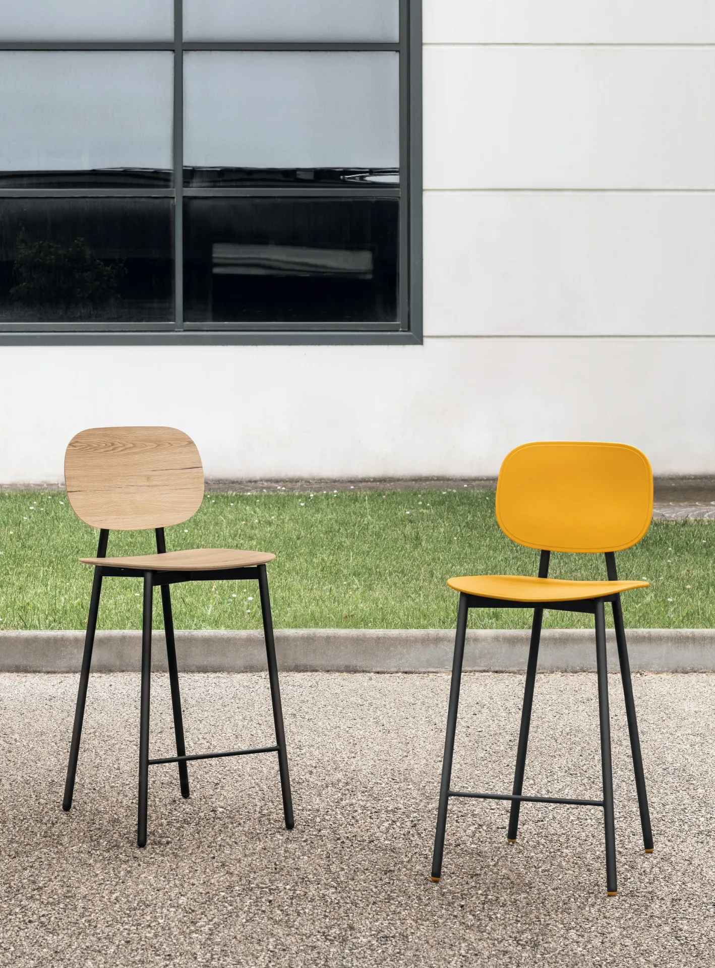 Sgabelli Painter Young Scavolini giallo ed effetto legno davanti a una vetrata sul prato