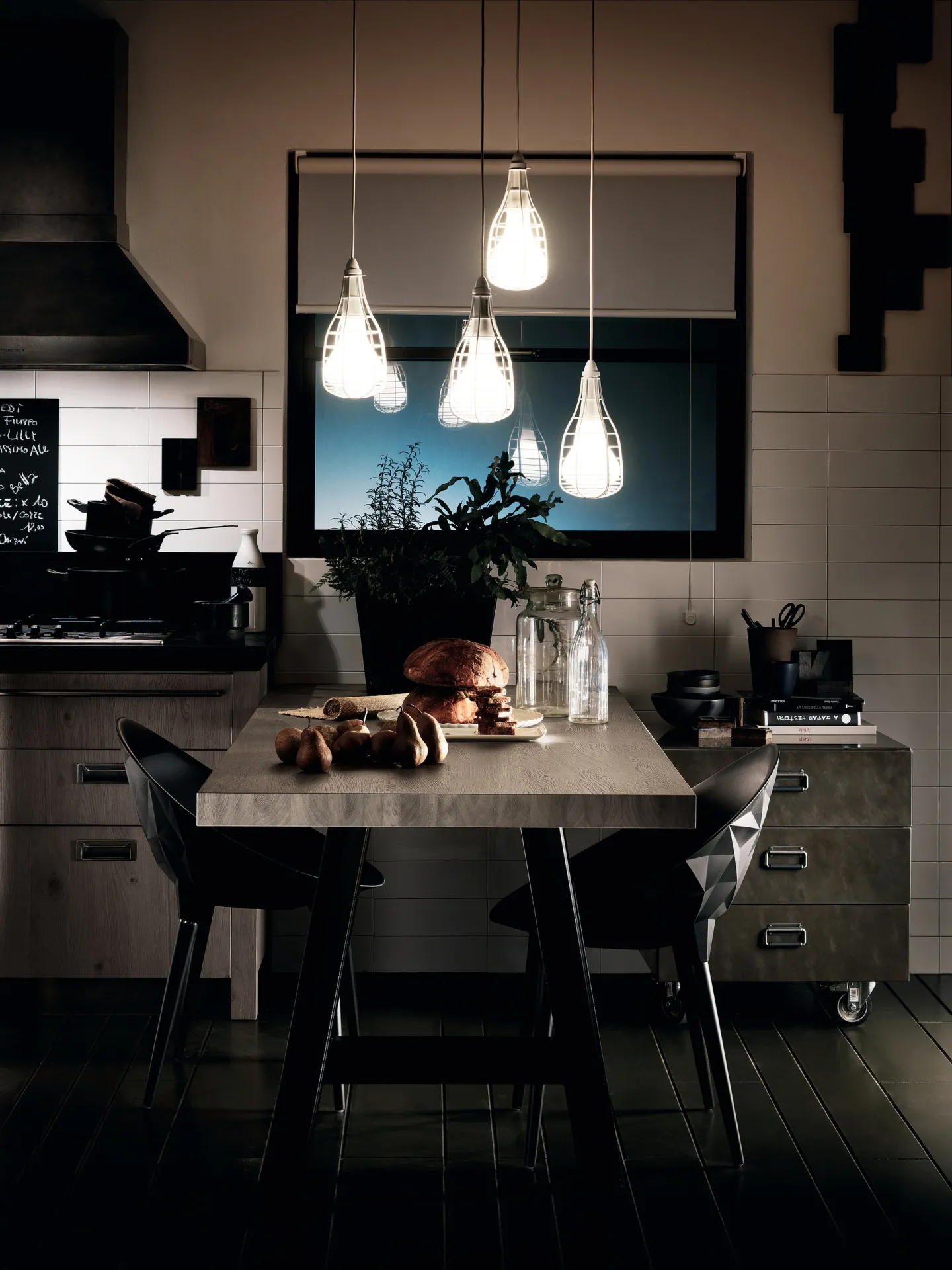 Sedie Rock Scavolini nere attorno a un tavolo in legno sotto lampade a goccia