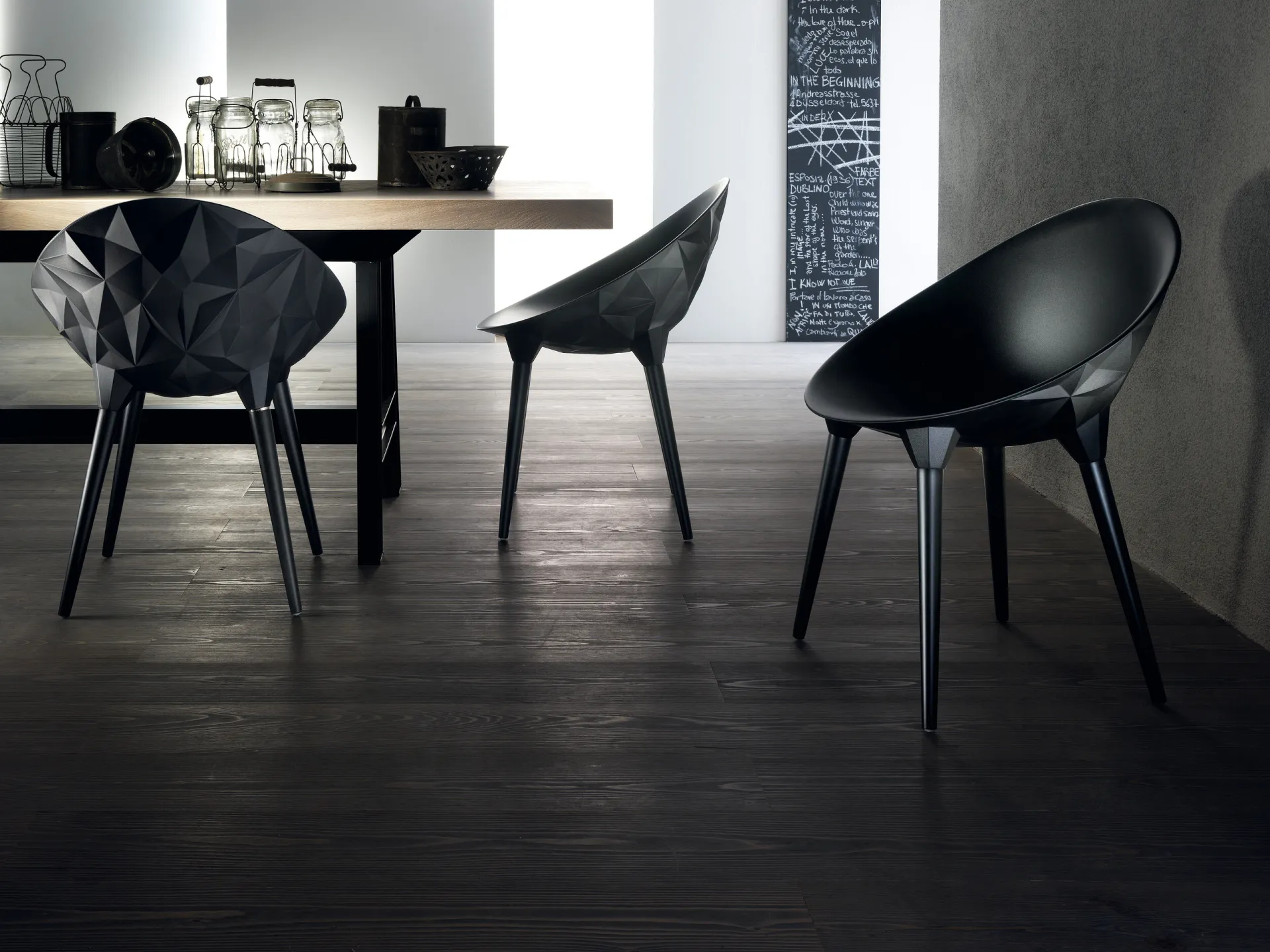 Sedie Rock Scavolini nere su un pavimento scuro accanto a un tavolo