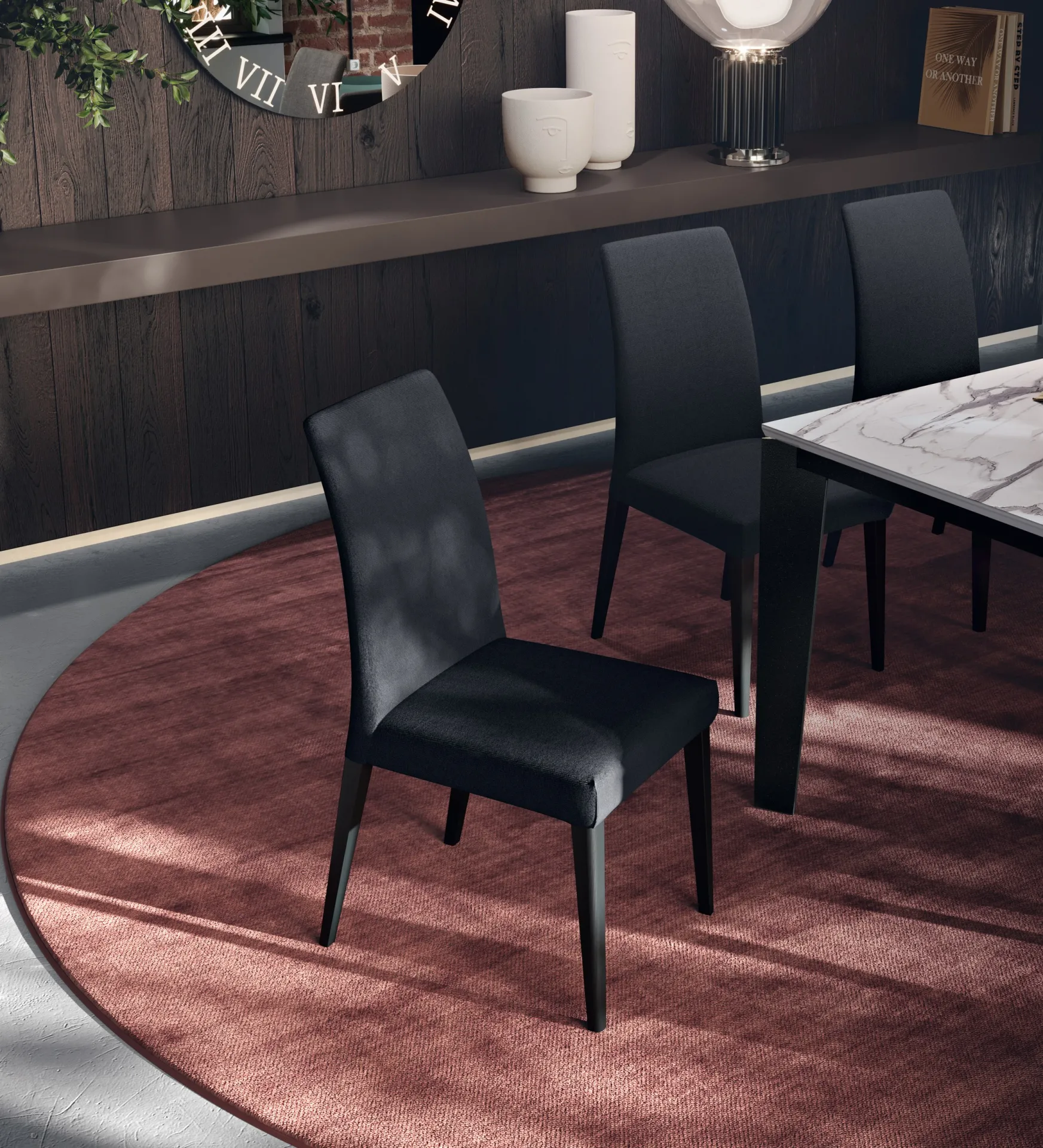 Sedie Tailor Scavolini antracite attorno a un tavolo in marmo su tappeto rosso