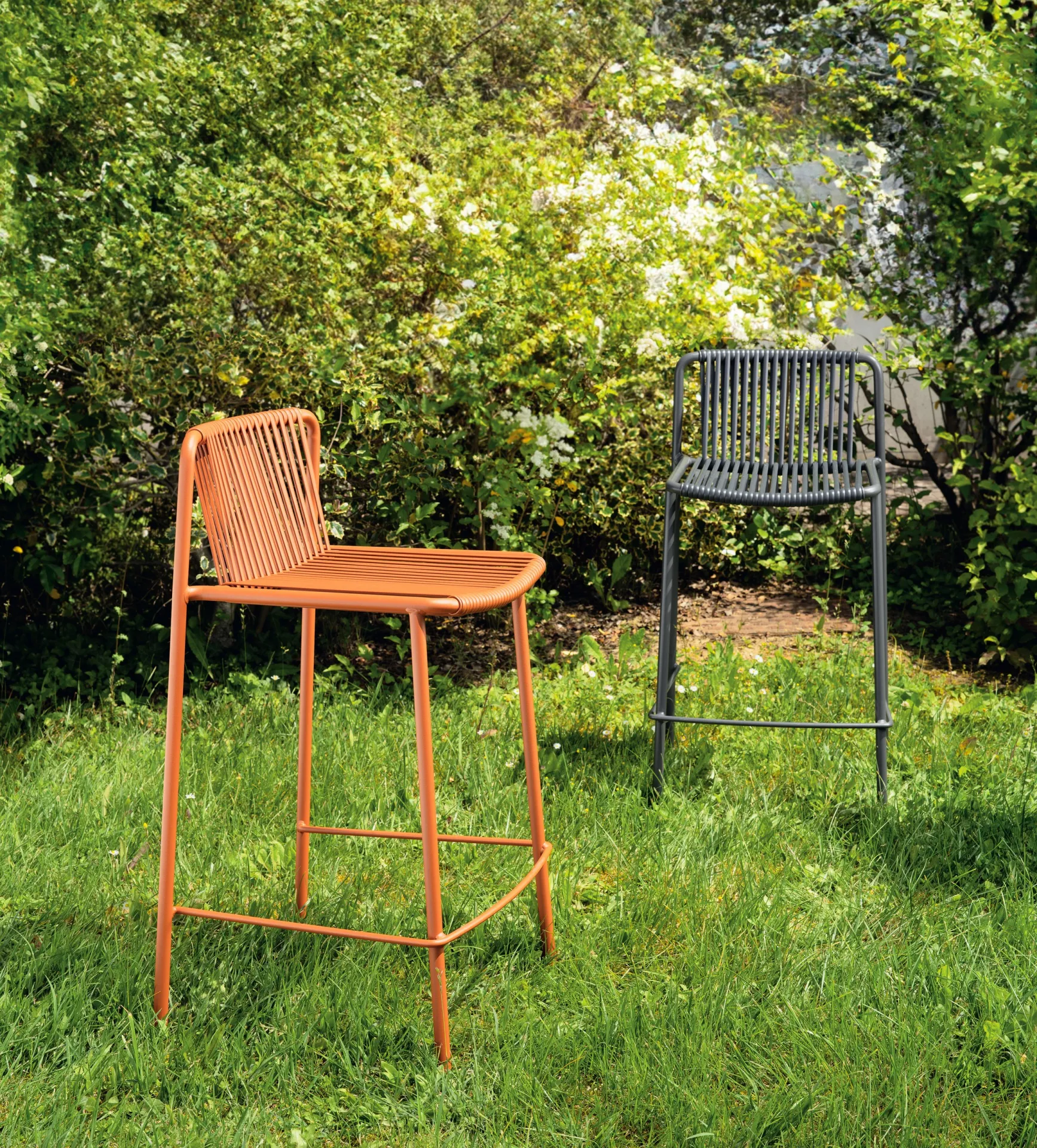 Sgabelli Tribeca Scavolini terracotta e grigio su un prato in giardino