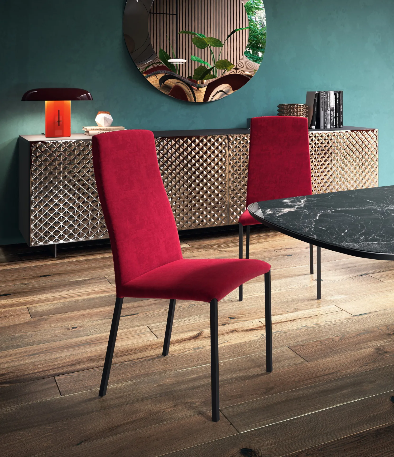 Sedie Wave Scavolini rosse attorno a un tavolo in marmo davanti a una parete verde